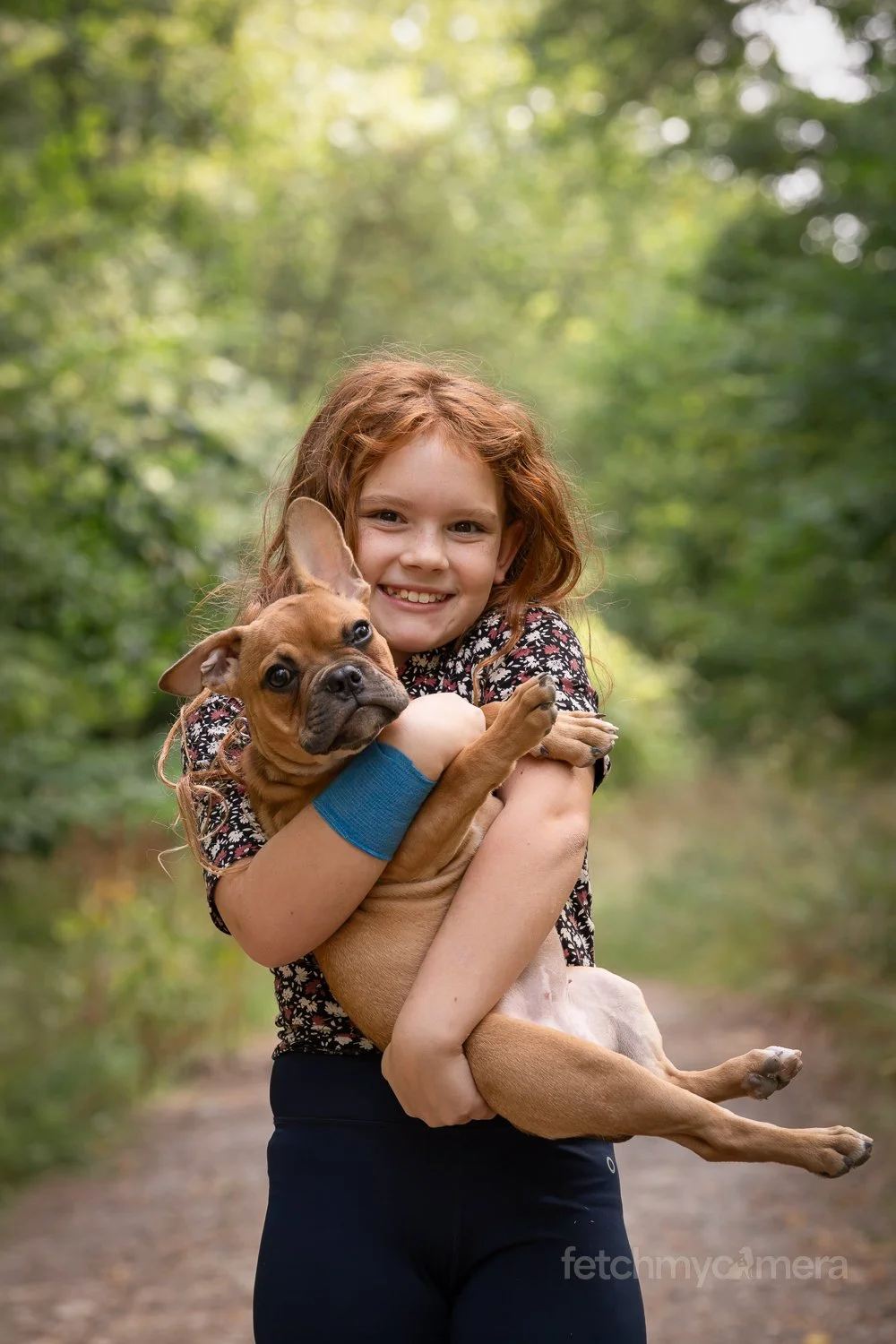 Little girl holding her French Bulldog