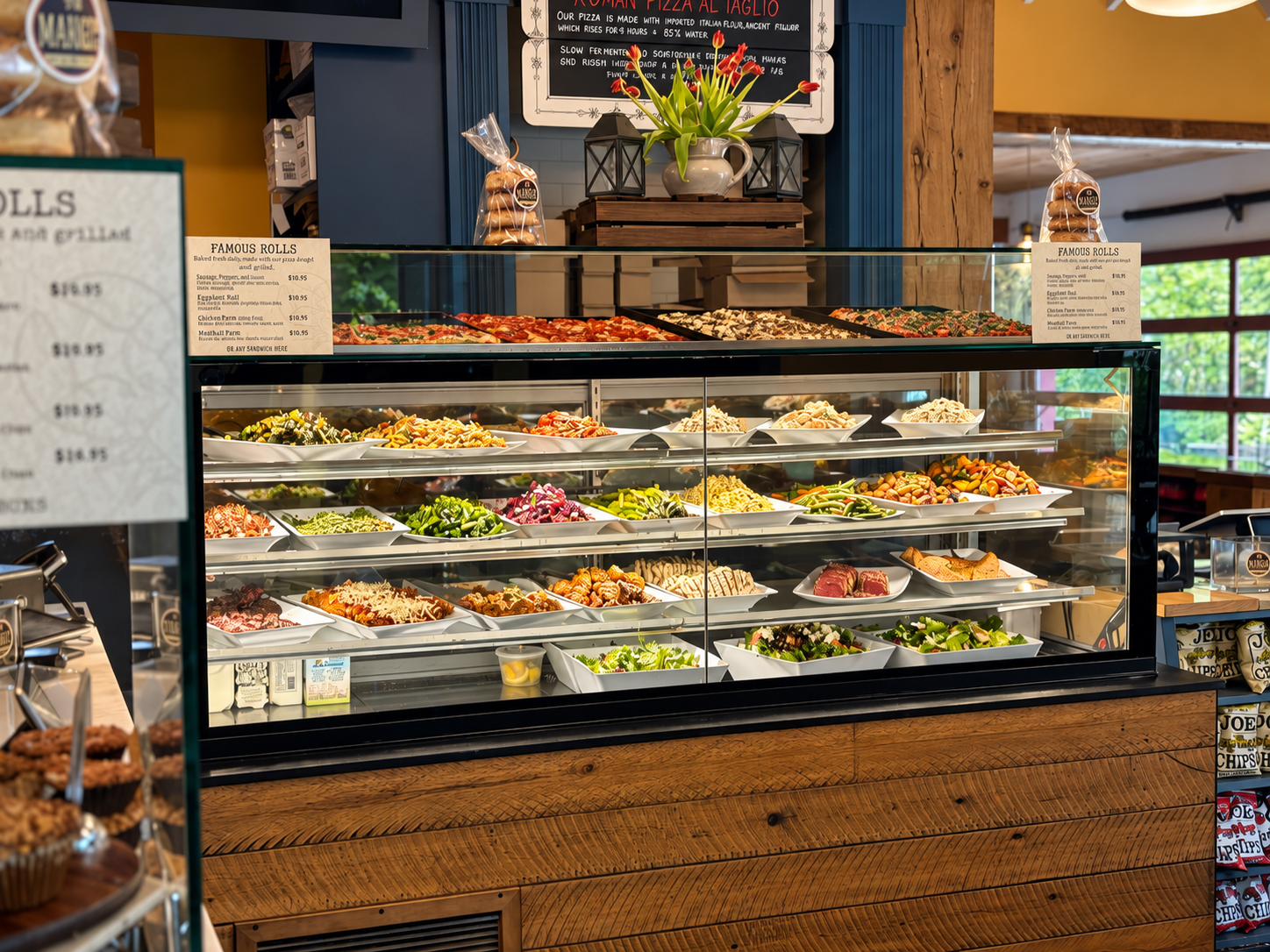 Display case filled with various salads and prepared foods in a grocery or deli store, with a blackboard menu above and wooden counter below.