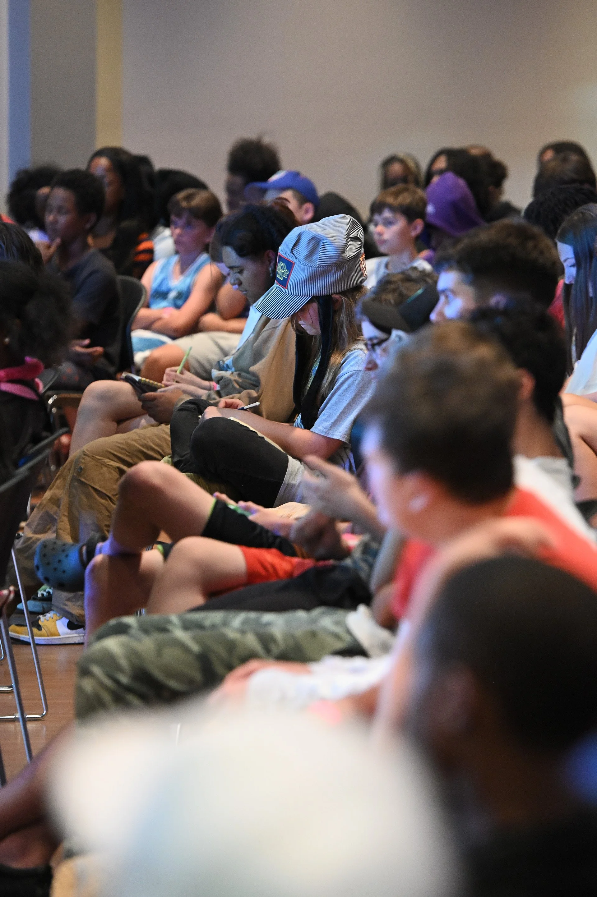 Young adults taking notes during a service event.