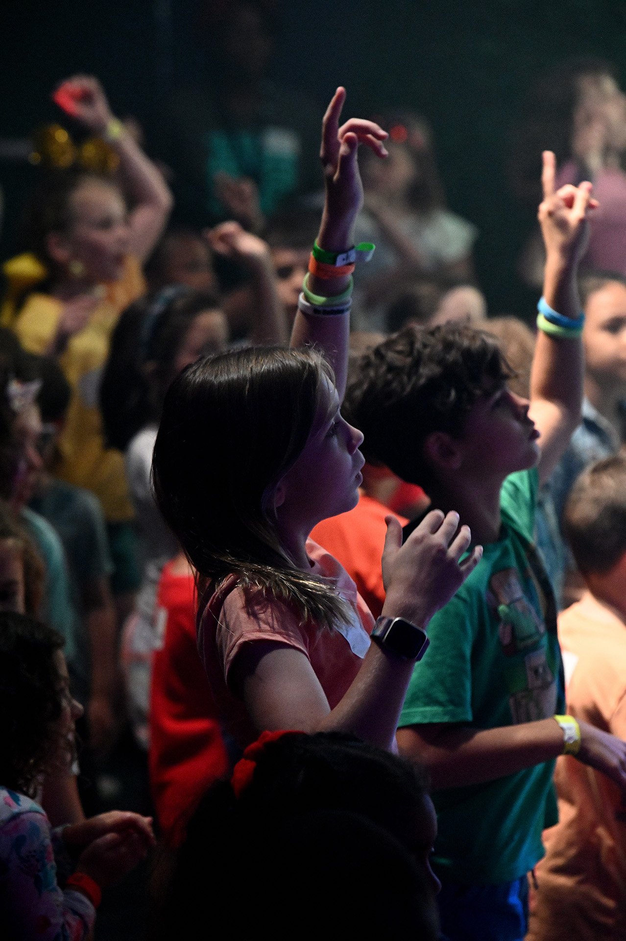 Elementary kids raising their hand during a Jr. Kids service.