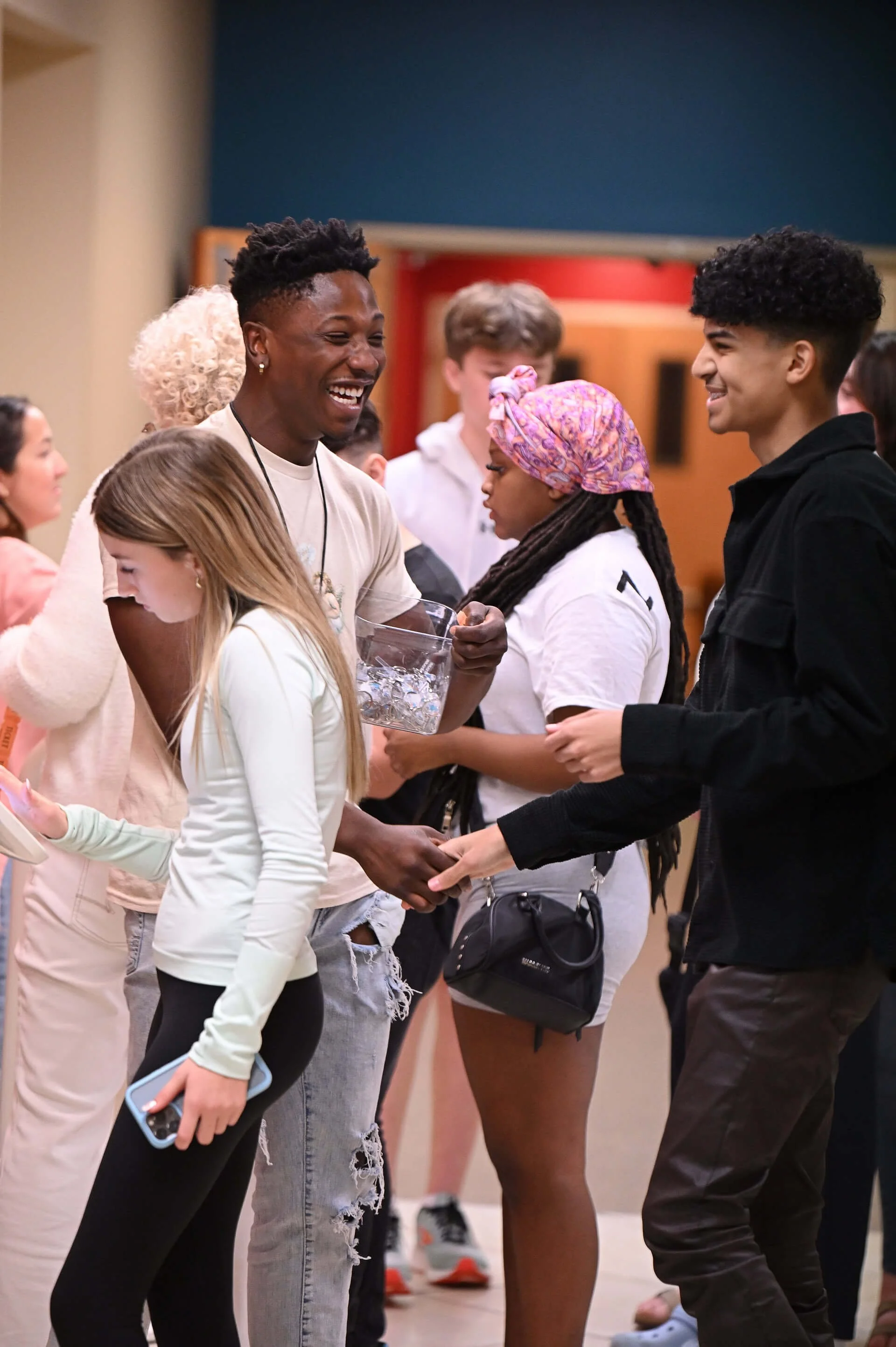 Teenagers happily greeting each other in the foyer of Family Worship Center.