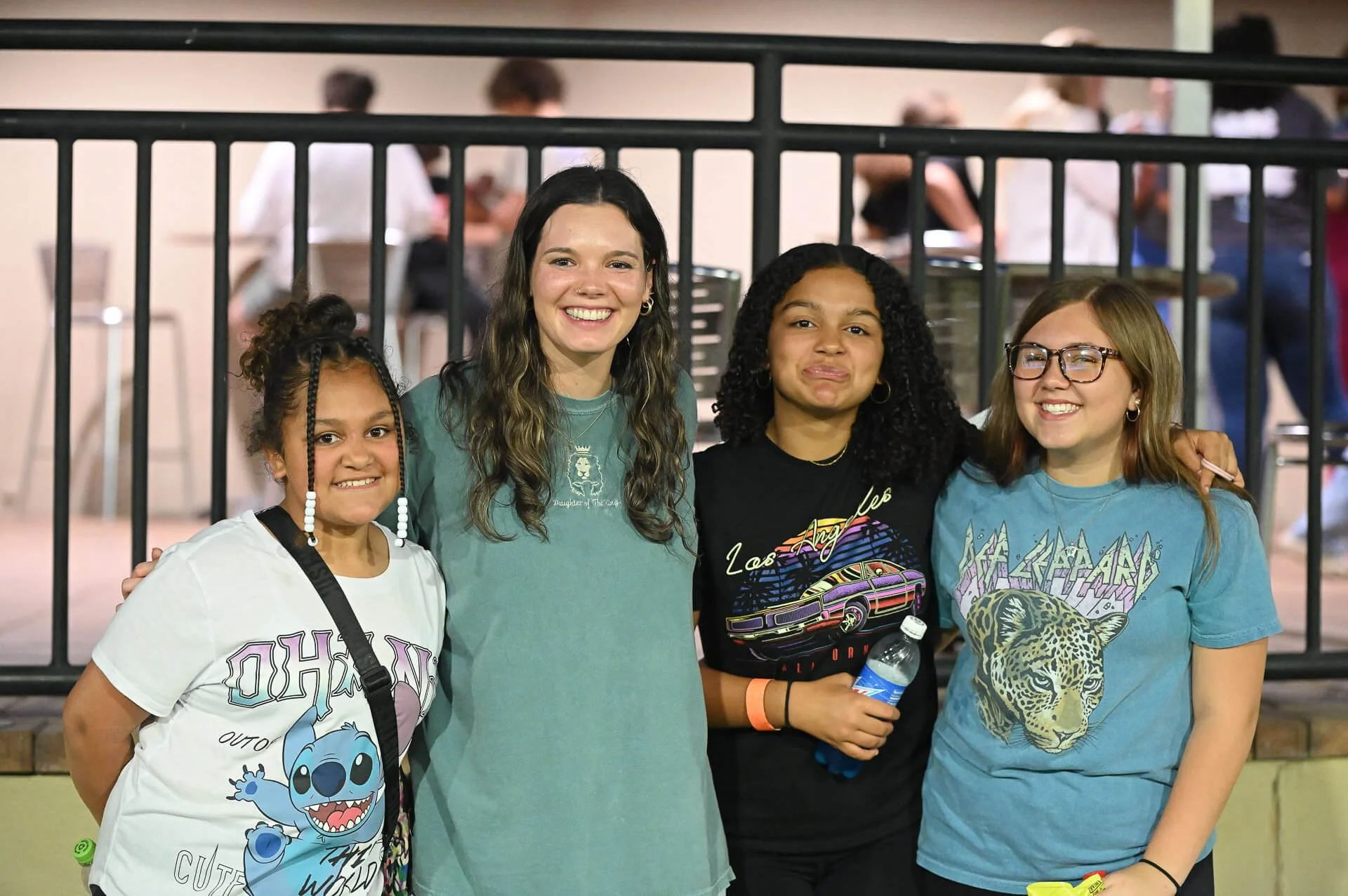 Four teenage girls laughing and smiling at the camera.
