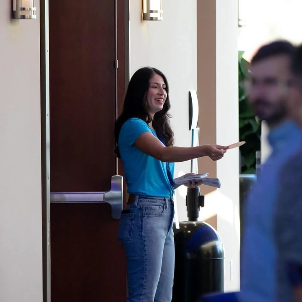 Woman handing out fliers at Family Worship Center