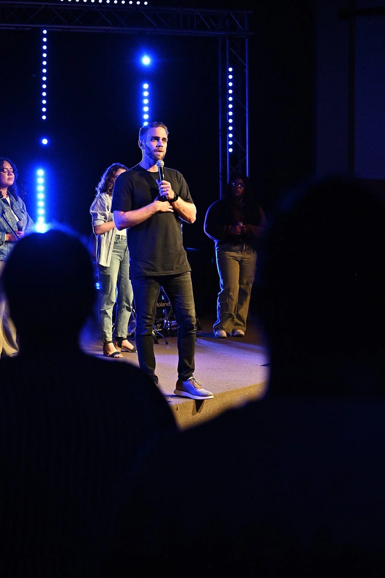 Young adult pastor talking on stage.