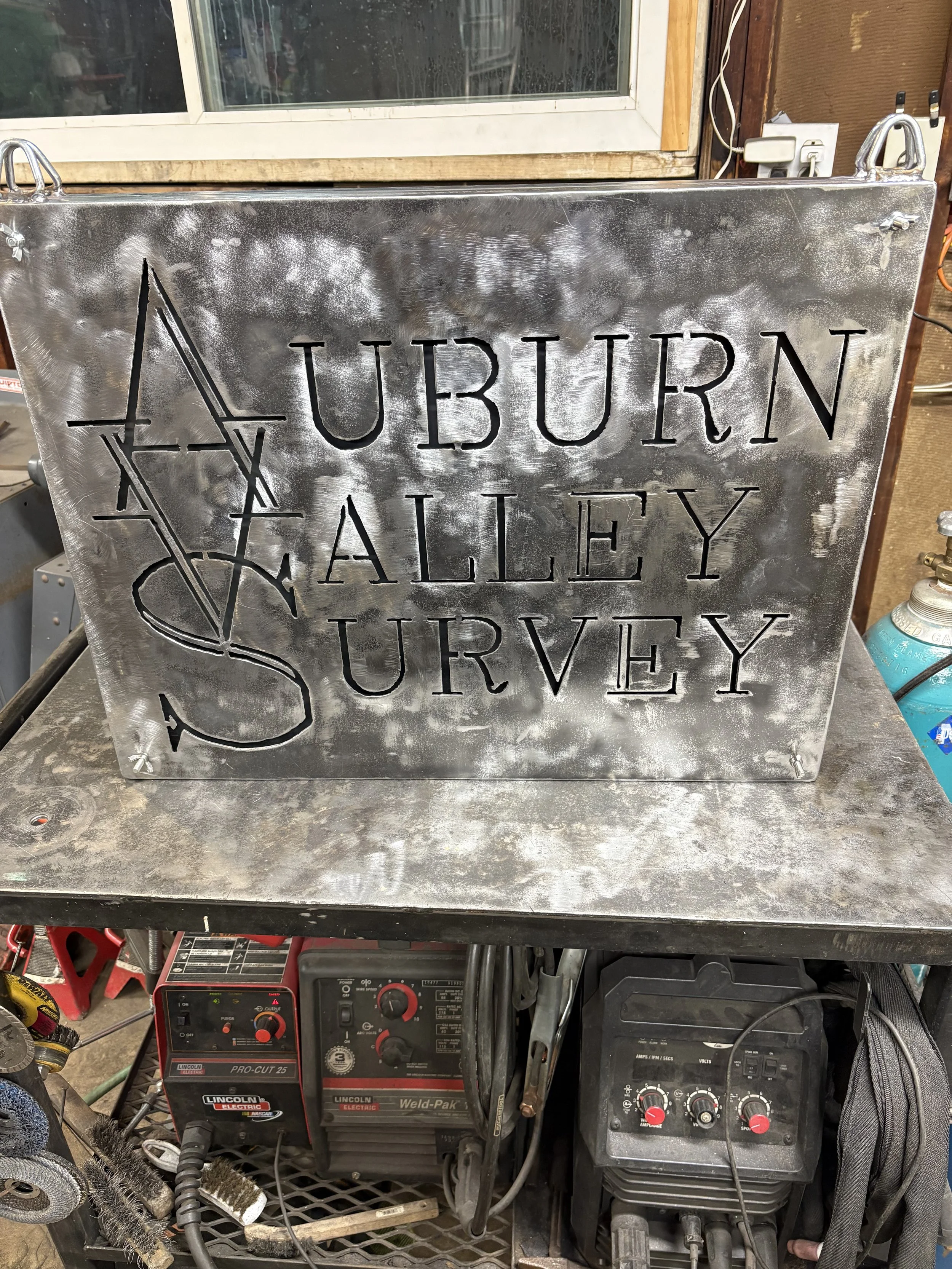 Metal sign with cutout text reading 'AUBURN VALLEY SURVEY'