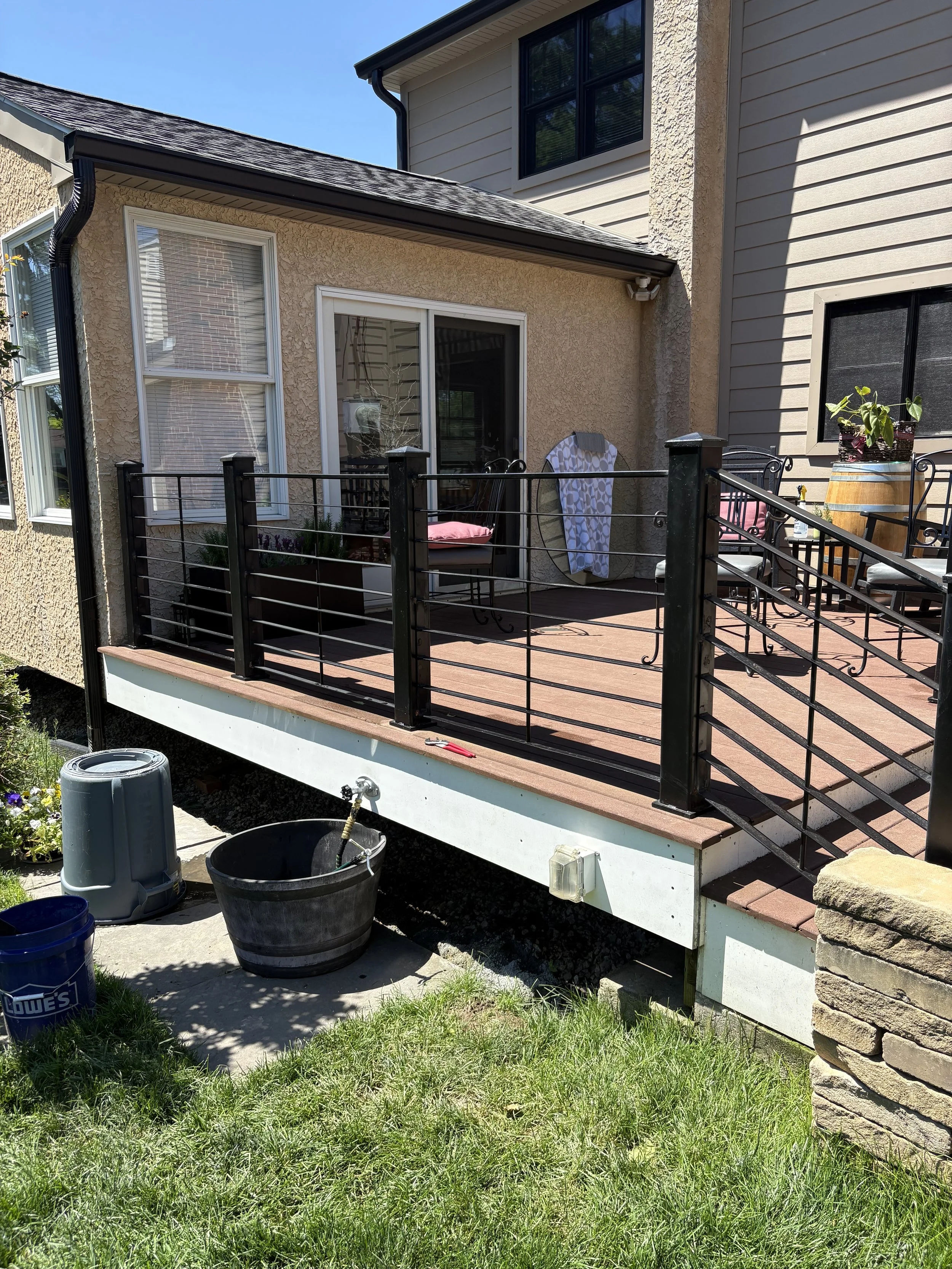 Backyard porch with black custom metal railing surrounding in Hockessin DE