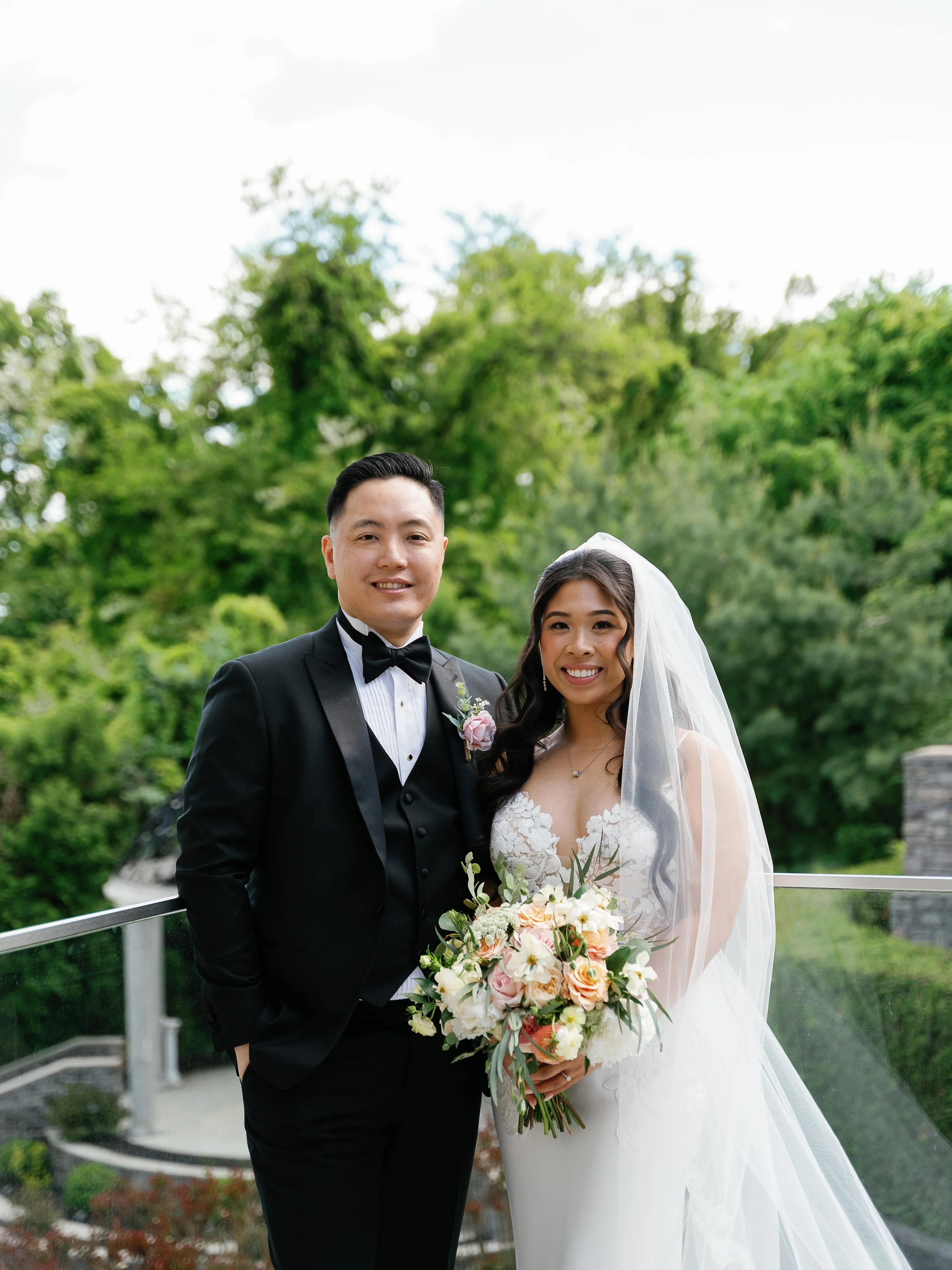 Laurie’s customers, Mariana and Carmen holding hands on a green lawn on their wedding day.