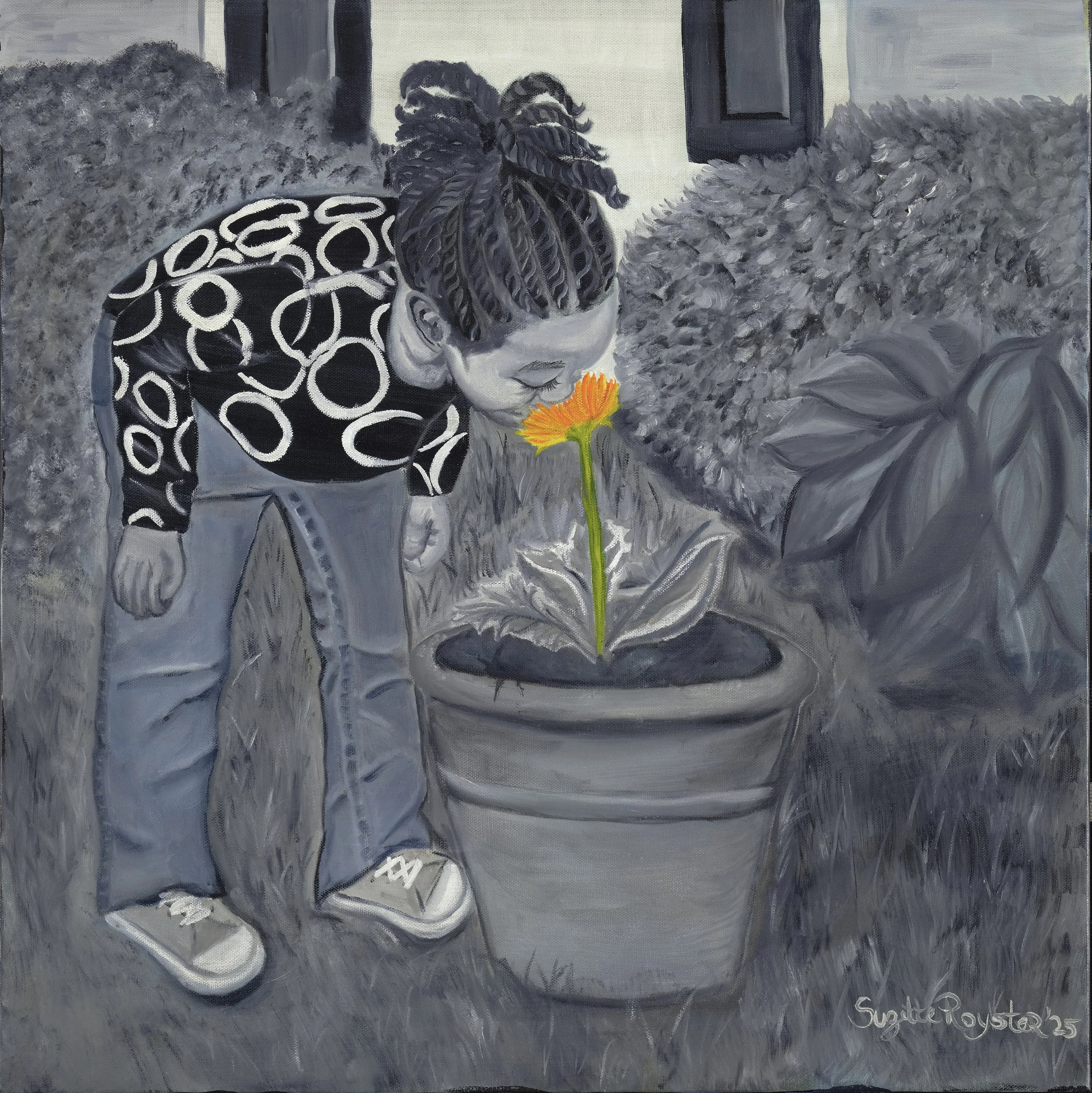 A woman with braided hair looking at a yellow flower with green stem in her hand. She is wearing a black and white patterned jacket and gray pants, standing on a gray surface with bushes and a building in the background.