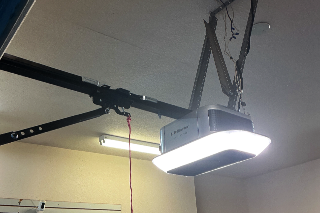 Garage ceiling with a mounted liftmaster garage door opener and an LED light panel.
