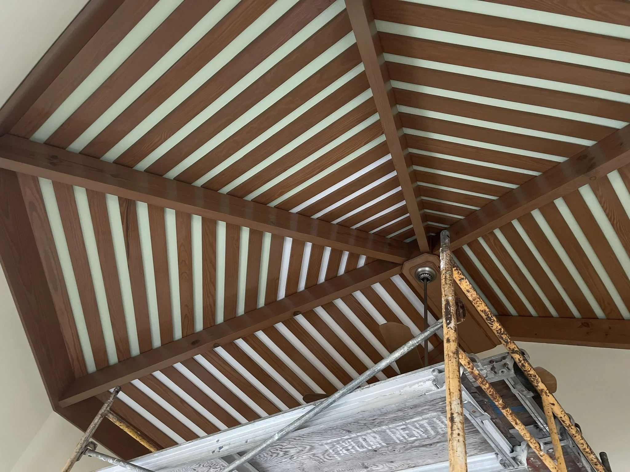 Detailed interior ceiling painting between exposed wood beams by HavenForged in Sarasota Florida.