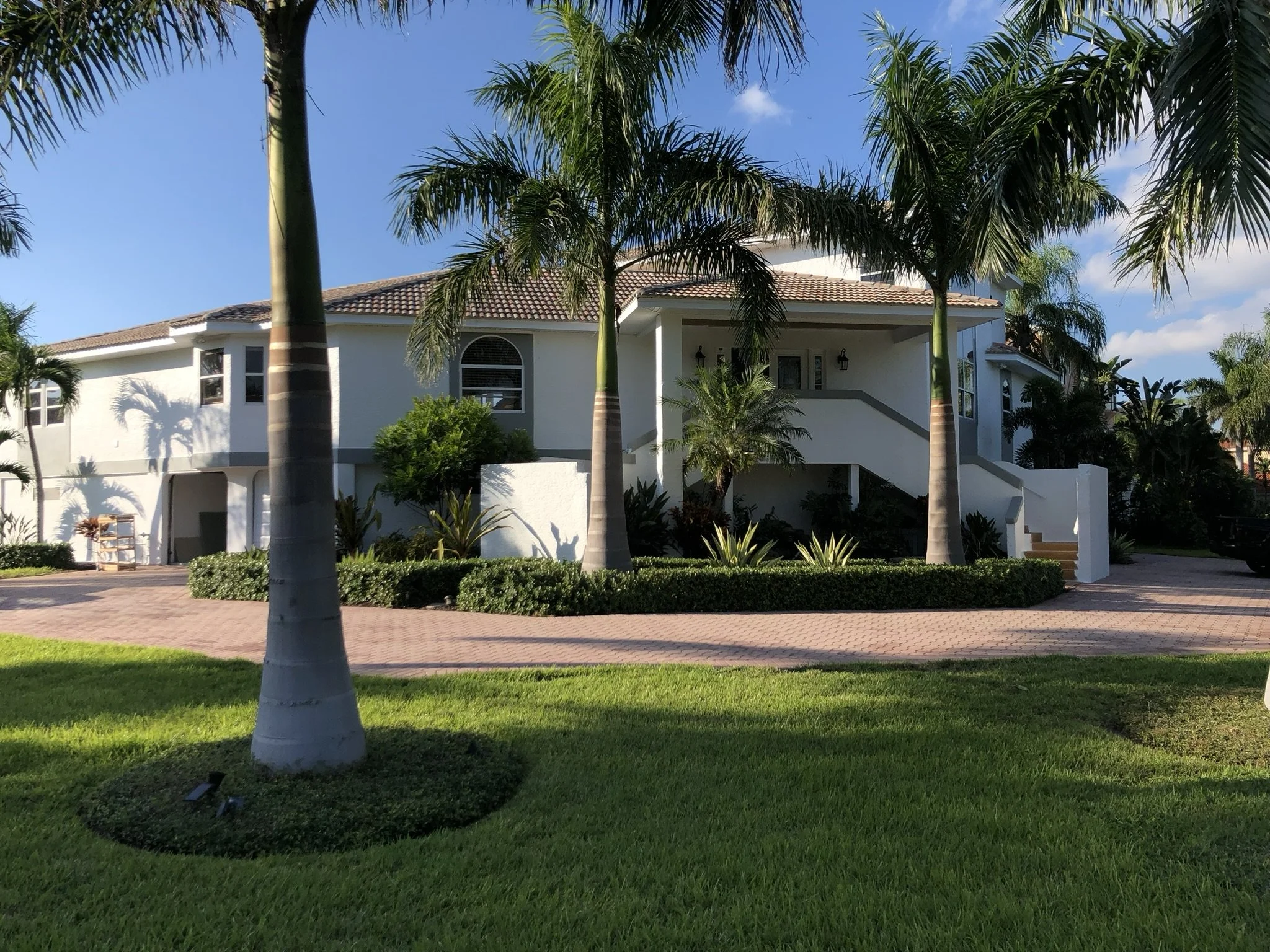 Complete exterior house painting with white walls, gray trim, white soffit and fascia, by HavenForged inf Sarasota Florida.