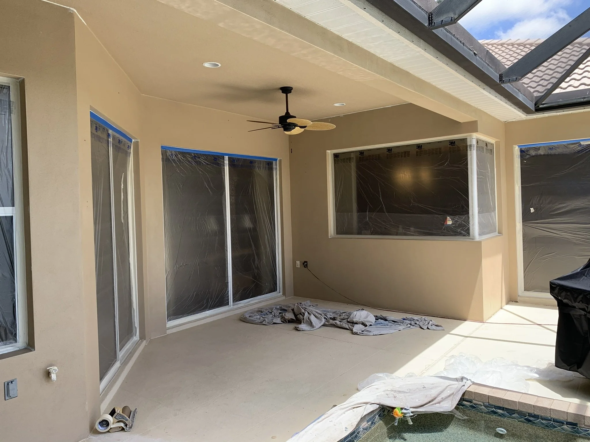 Exterior painting preparation with sliding glass doors and windows protected before painting by HavenForged in Sarasota Florida.