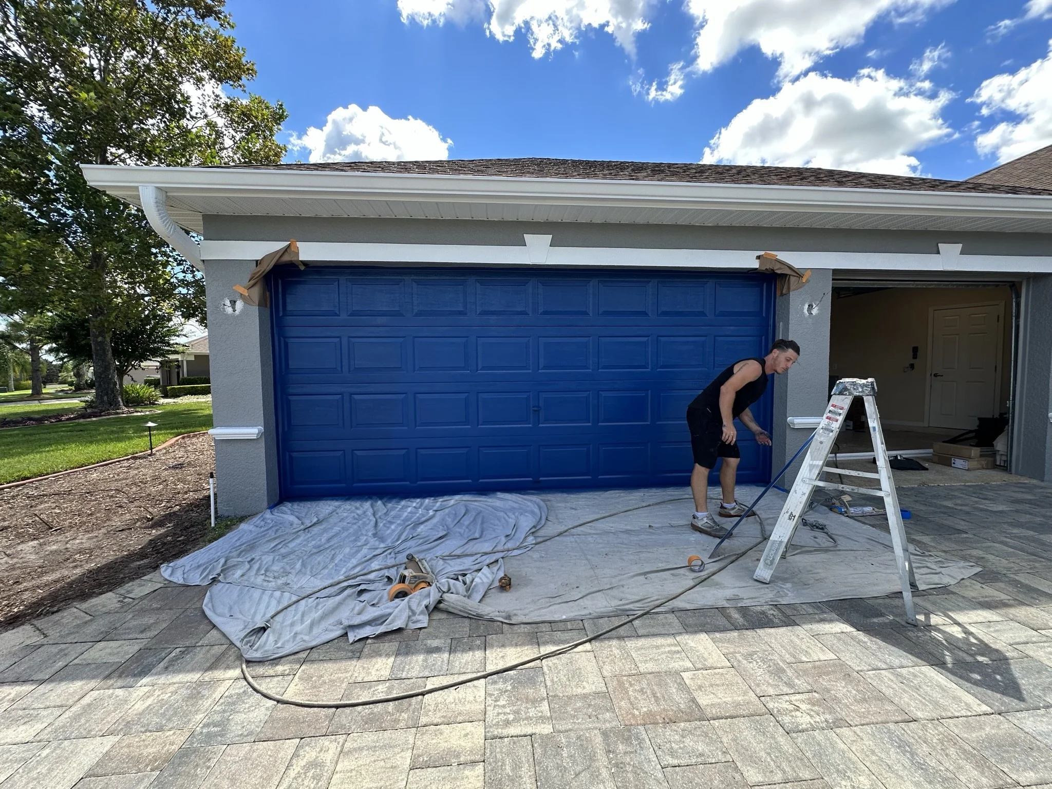 HavenForged exterior painting project in progress with garage doors and trim preparation in Sarasota, FL.