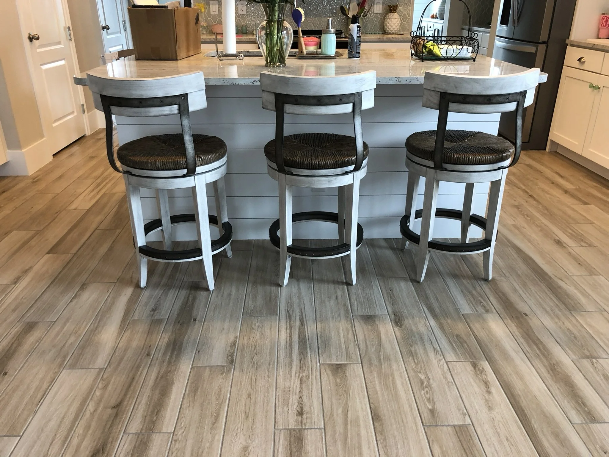 Home remodeling with new flooring, painted walls and trim, and custom decorative island paneling installed and painted by HavenForged in Sarasota, FL.
