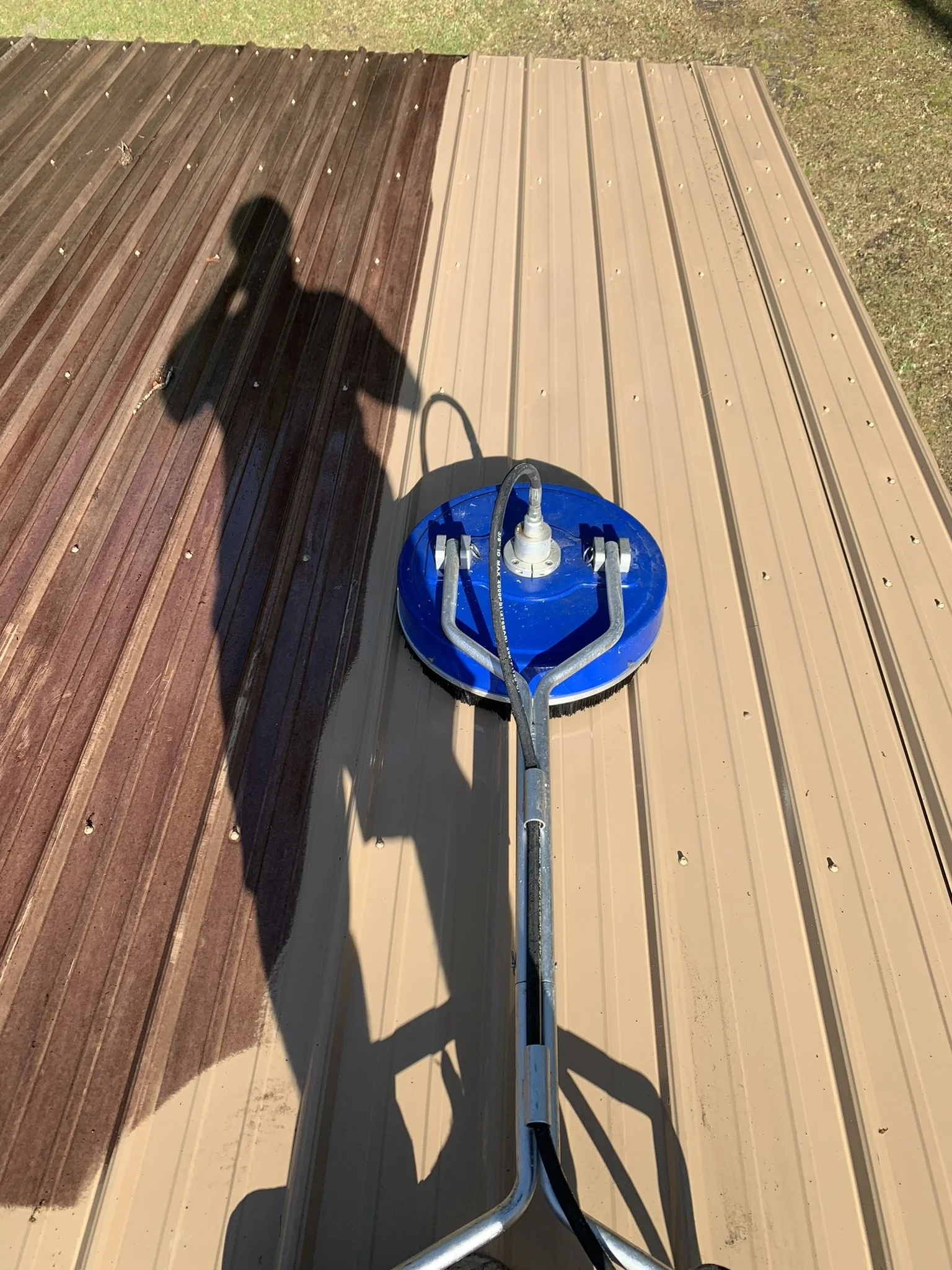 Pressure cleaning a metal roof as part of HavenForged property maintenance services in Sarasota, Florida.
