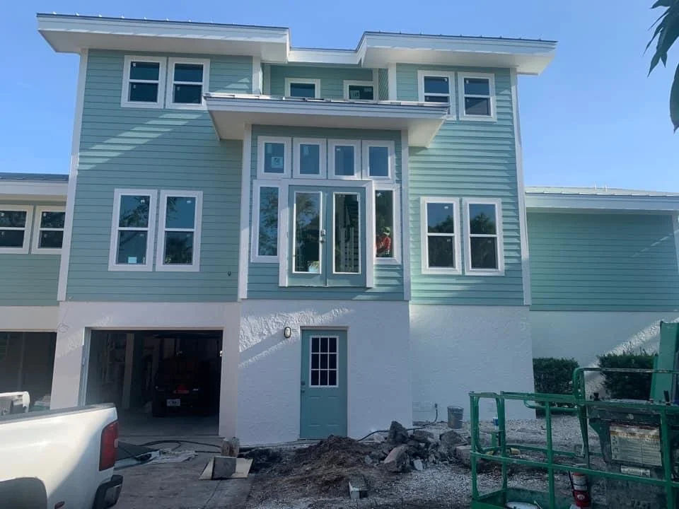 Completed residential exterior painting with teal siding, white trim, fascia and soffits by HavenForged in Sarasota, FL.