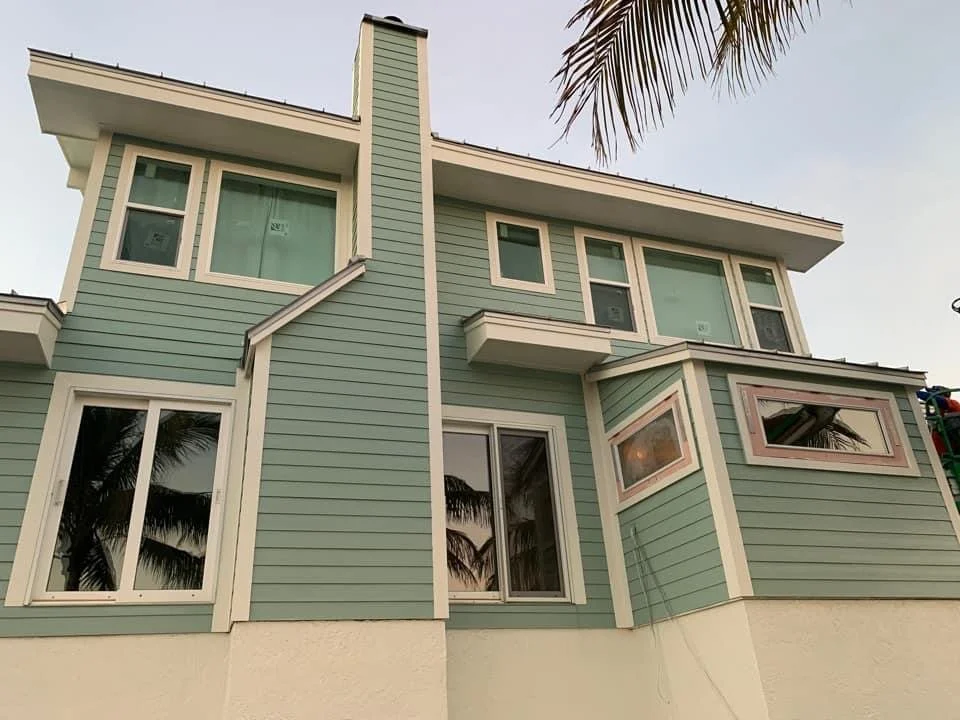 Completed multi-story home exterior with teal siding, white trim, and finished architectural details by HavenForged in Sarasota, Florida.