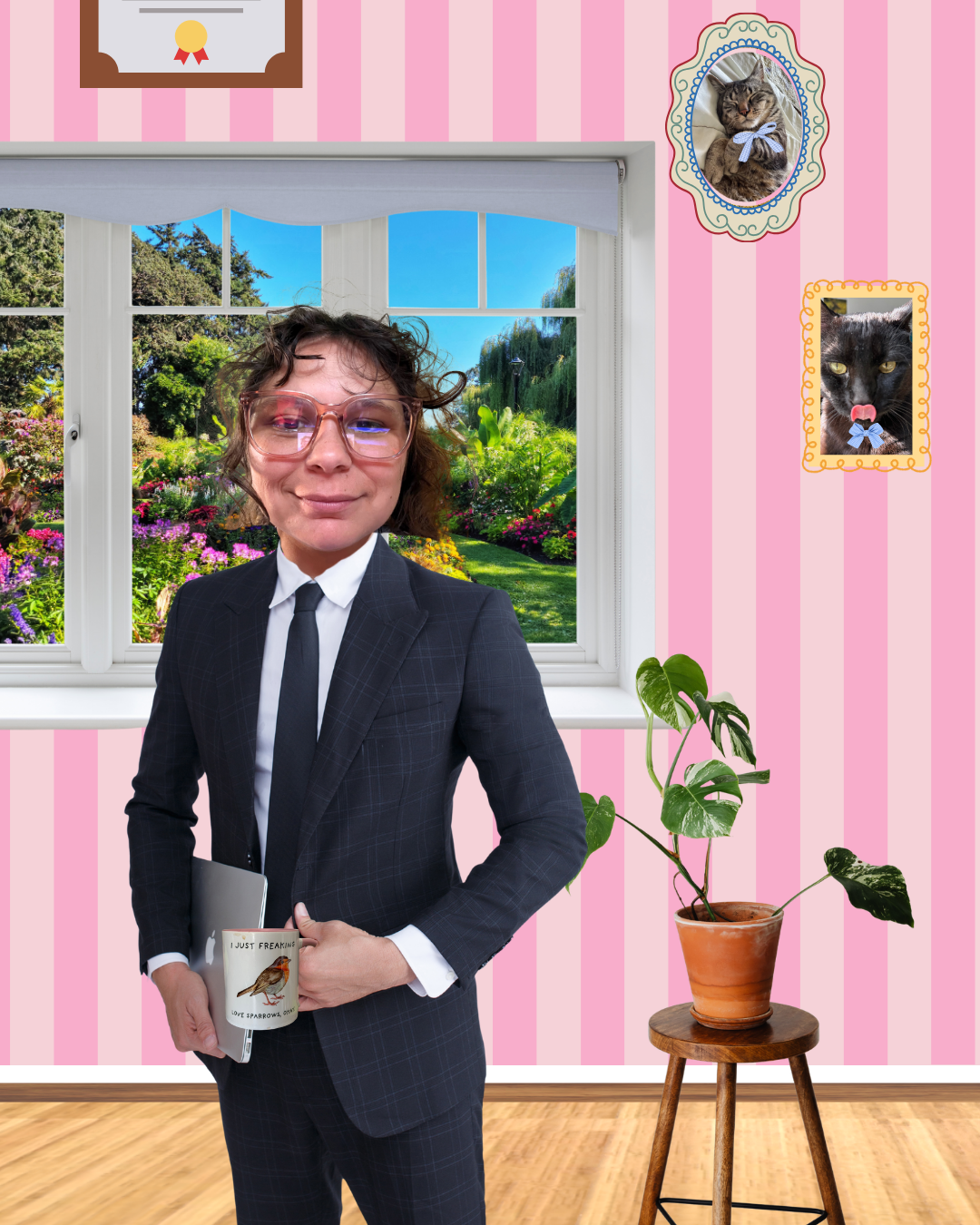 A woman in a business suit with glasses standing inside a pink, striped room, holding a mug with a bird illustration, in front of a window with a garden view. There are framed pictures of cats on the wall and a potted plant on a wooden stand.