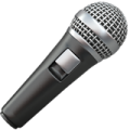 A close-up of a handheld microphone with a metallic grill and black body.