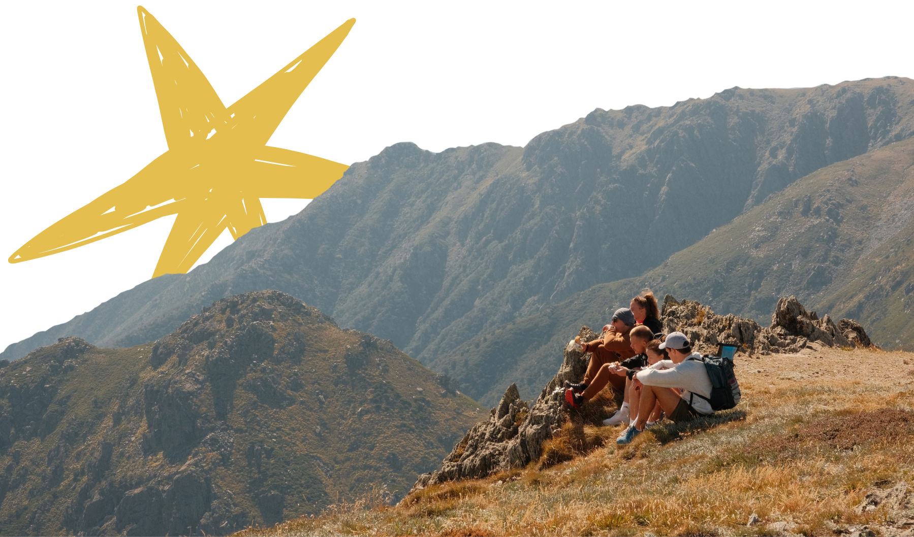 A group of five hikers resting and eating snacks in Kosciuszko National Park in NSW on a rocky ledge in the mountains, with rugged peaks and valleys in the background.