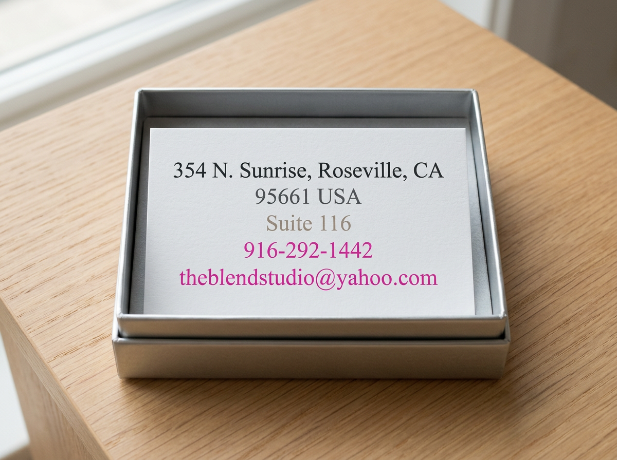 Contact information card inside a silver tray on a wooden surface, including an address in Roseville, CA, a suite number, phone number, and email address.