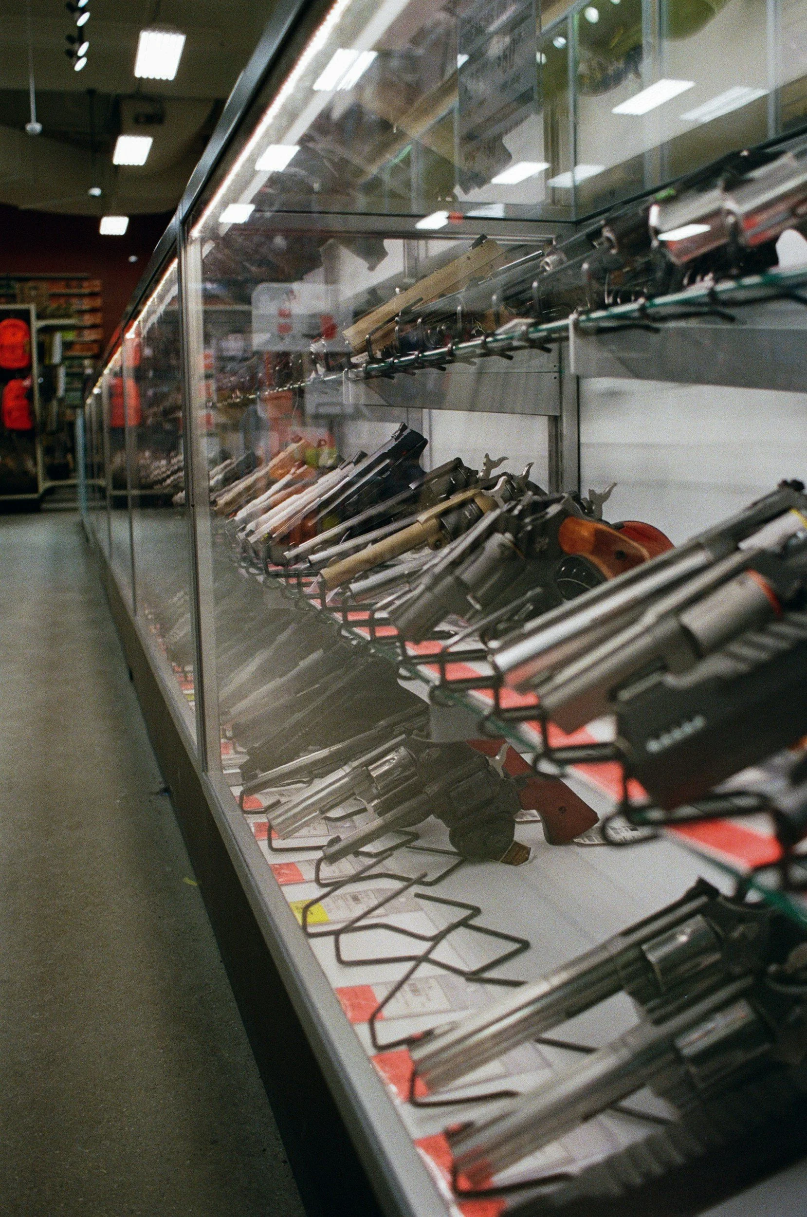 Display case with various handguns and rifles inside a store.