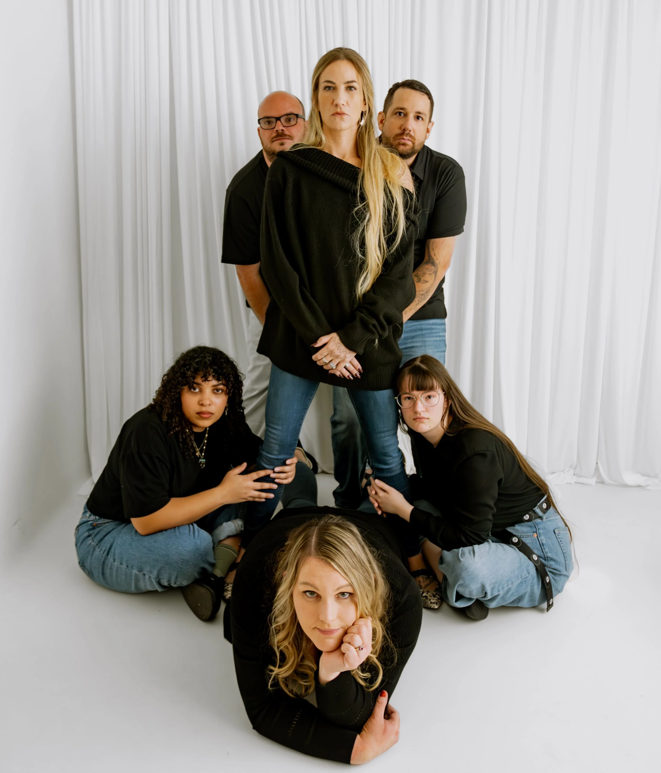 Breakthroughs LLC staff members posing for black shirts and jeans straight-faced theme.