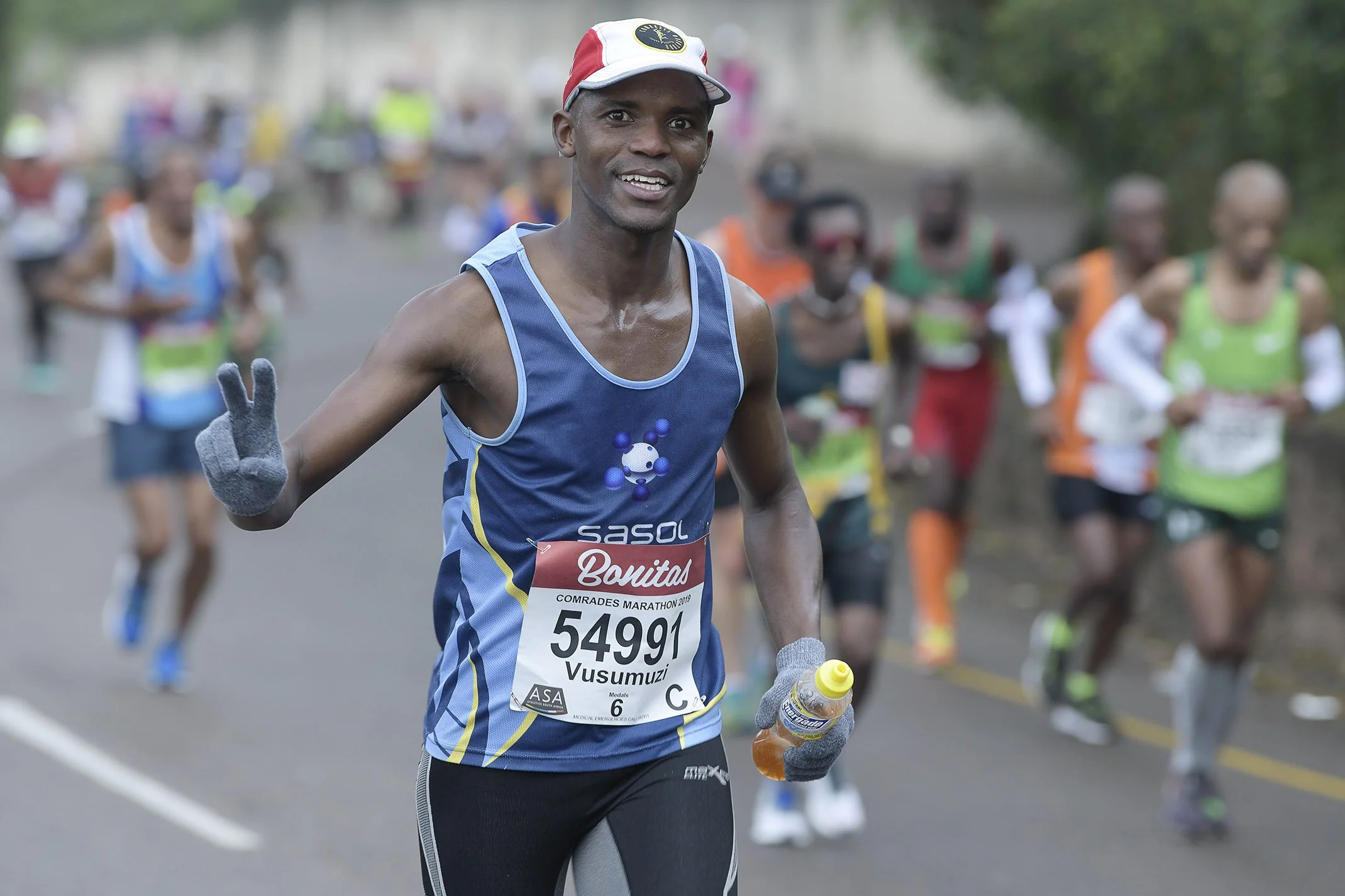 Cheerful athlete running in Comrades Ultramarathon showing the spirit of the race