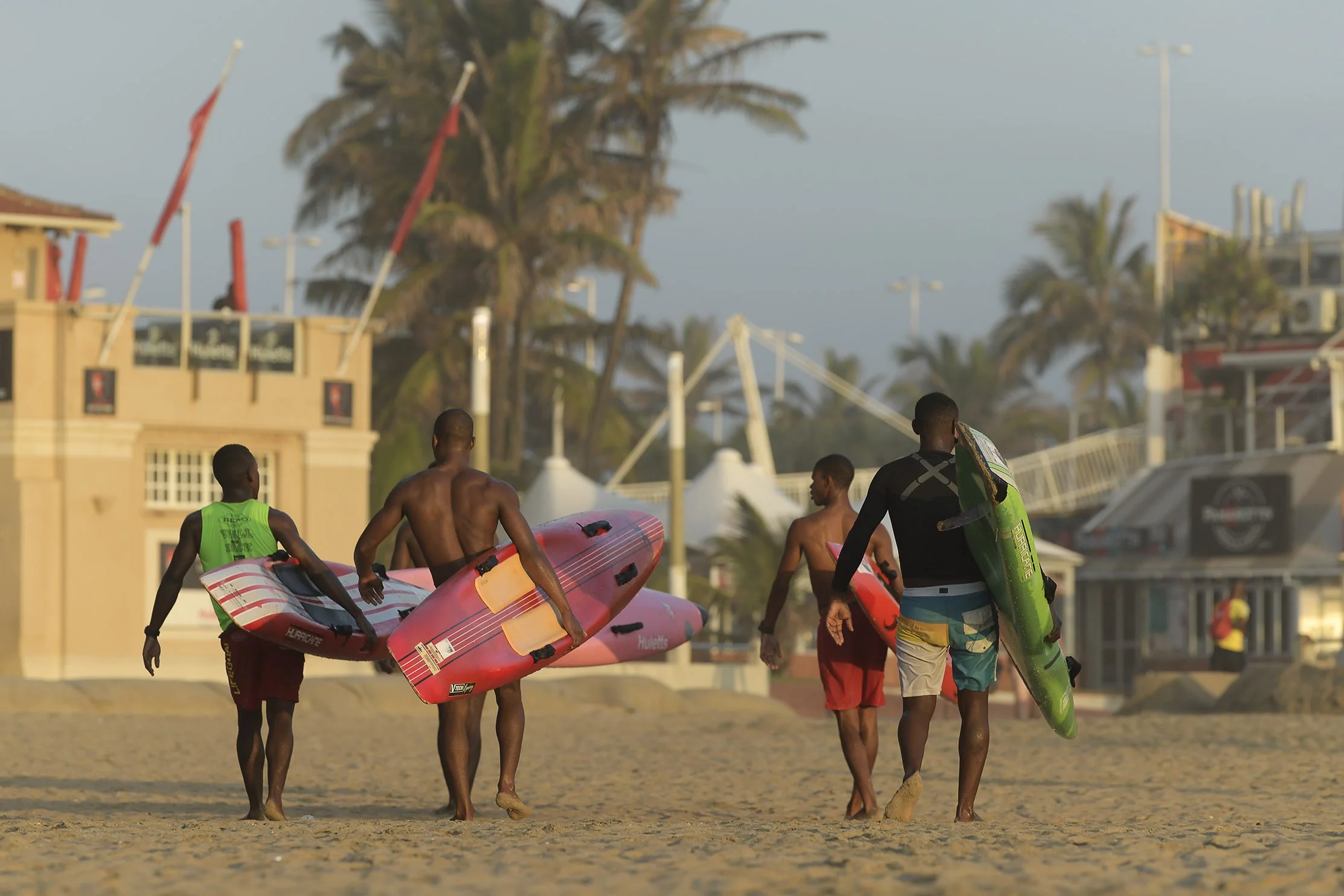 Rear view of fit lifeguards walking to their lookout station after morning training