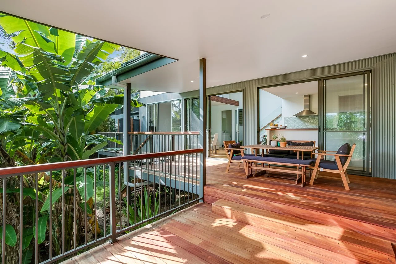 Outdoor entertaining area featuring sage green cladding, timber decking and a seamless connection between indoor and outdoor living.jpg