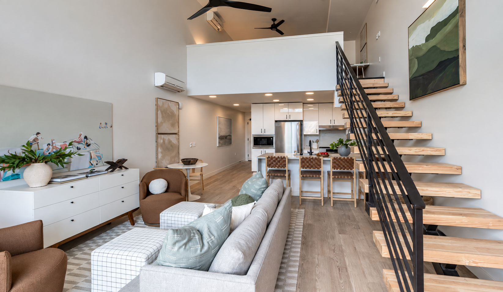 Finished custom home interior with kitchen, living area, and floating stair by Timber & Iron Construction Company