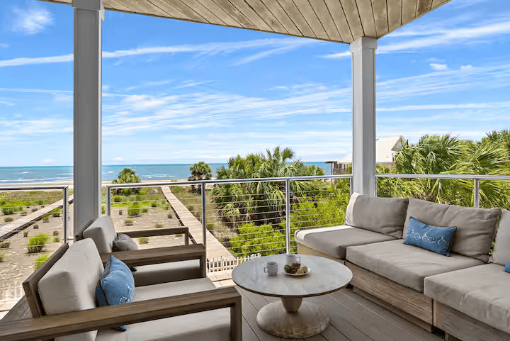 patio furniture on deck overlooking ocean with blue sky above