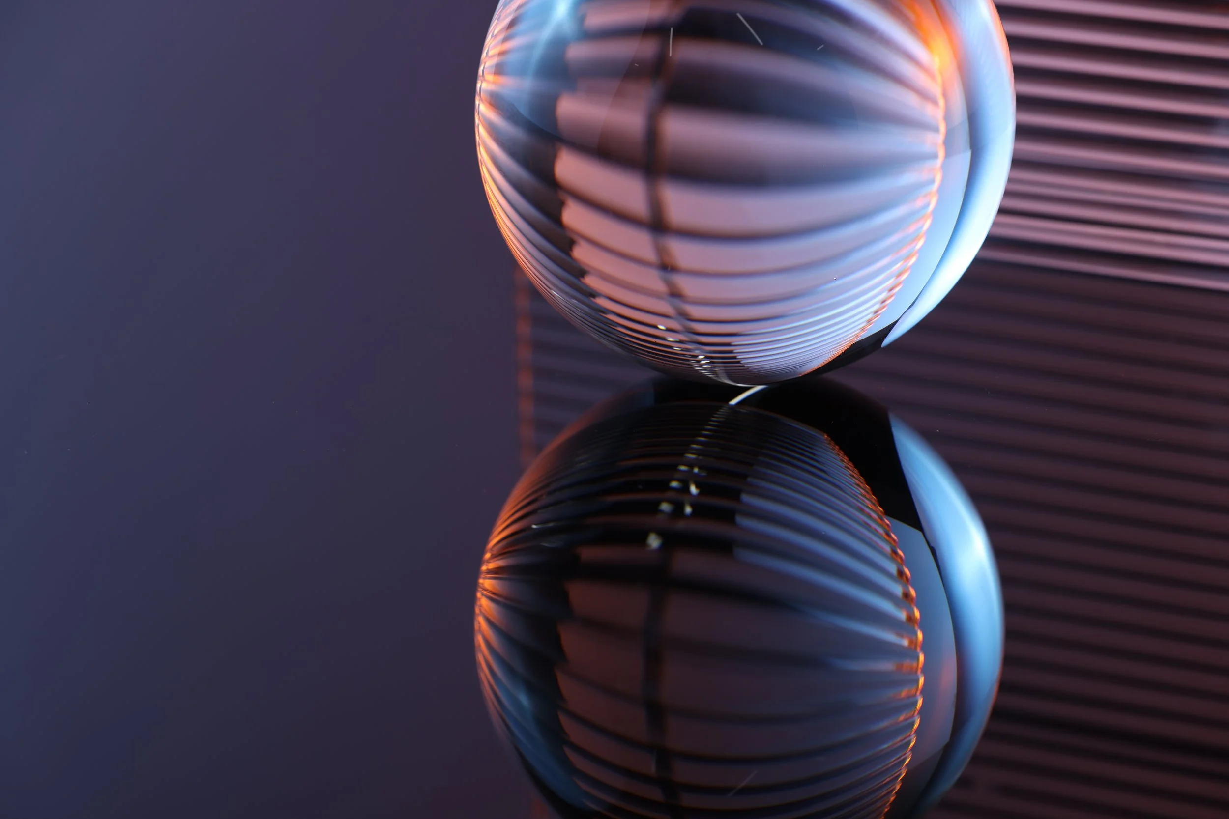 Glass orb reflected on a glossy surface