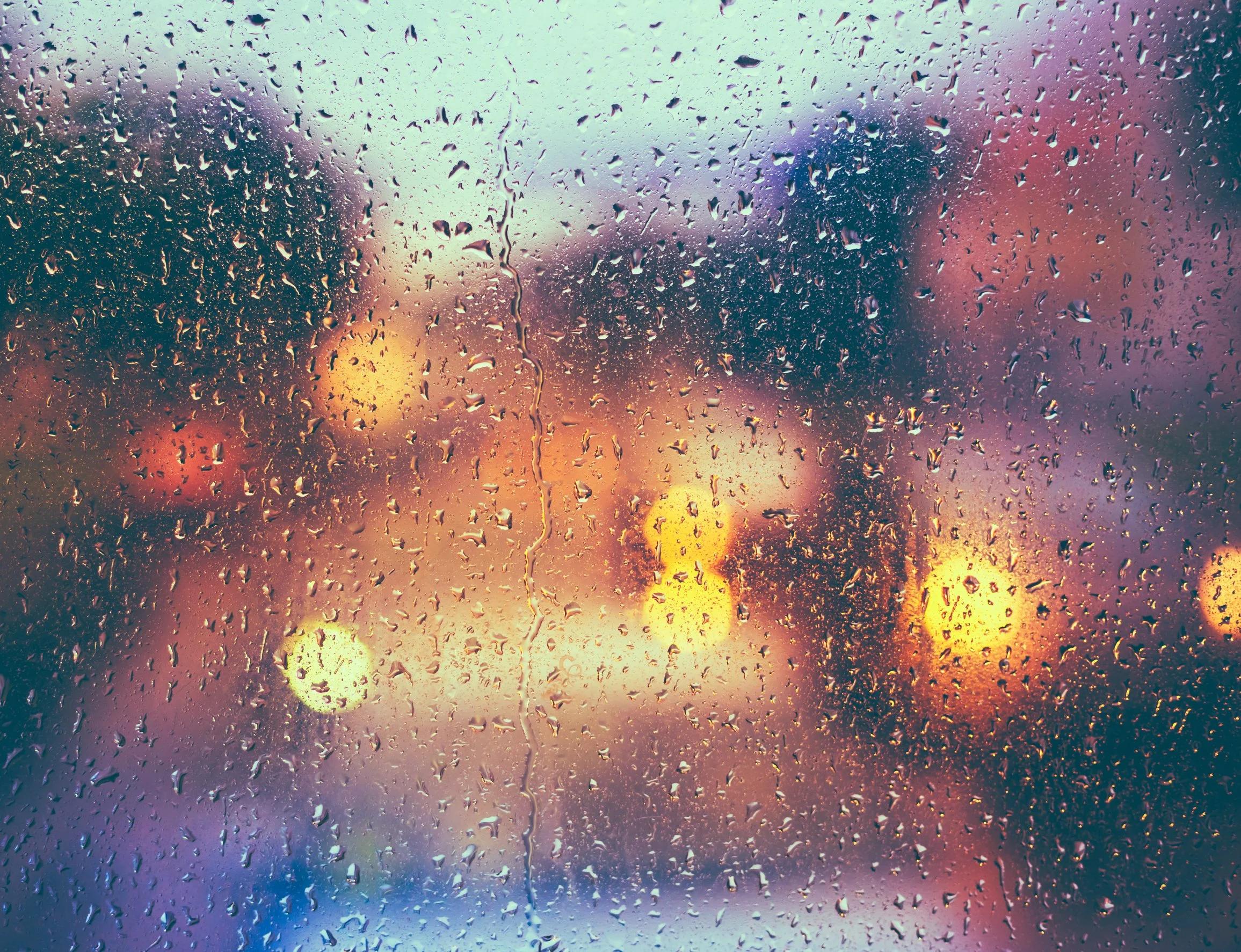 Raindrops on a window with blurred city lights