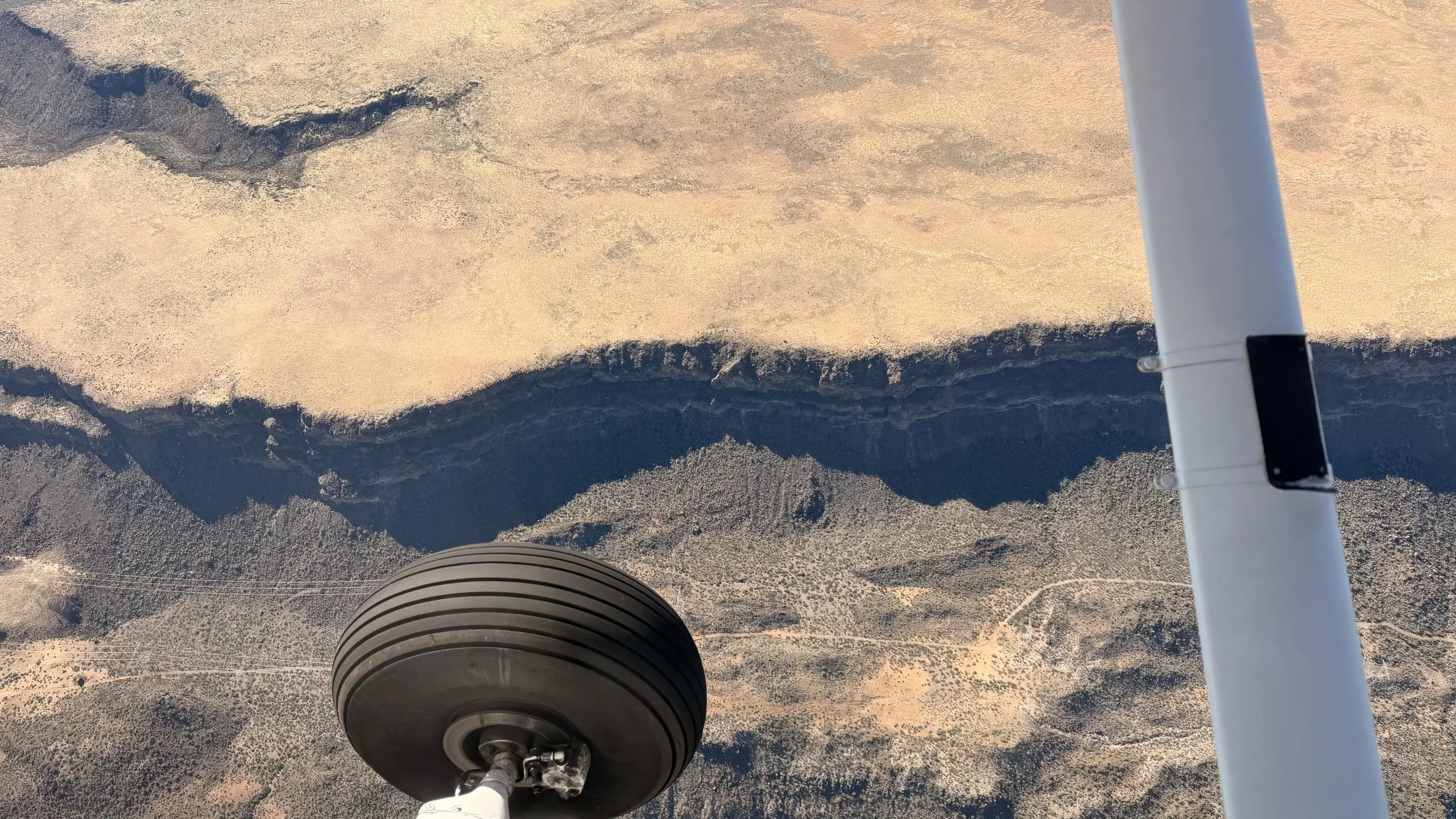 View under the wing of a Wind Walker Cessna in flight over Sonoran Desert, Tucson, Arizona.