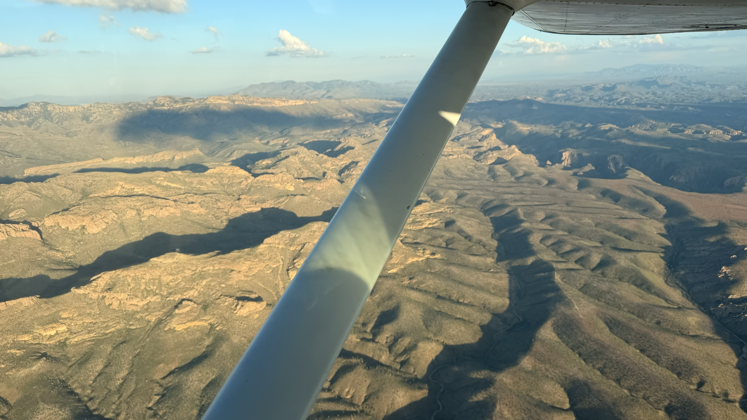Desert canyon and mountains seen from a Wind Walker Cessna in flight