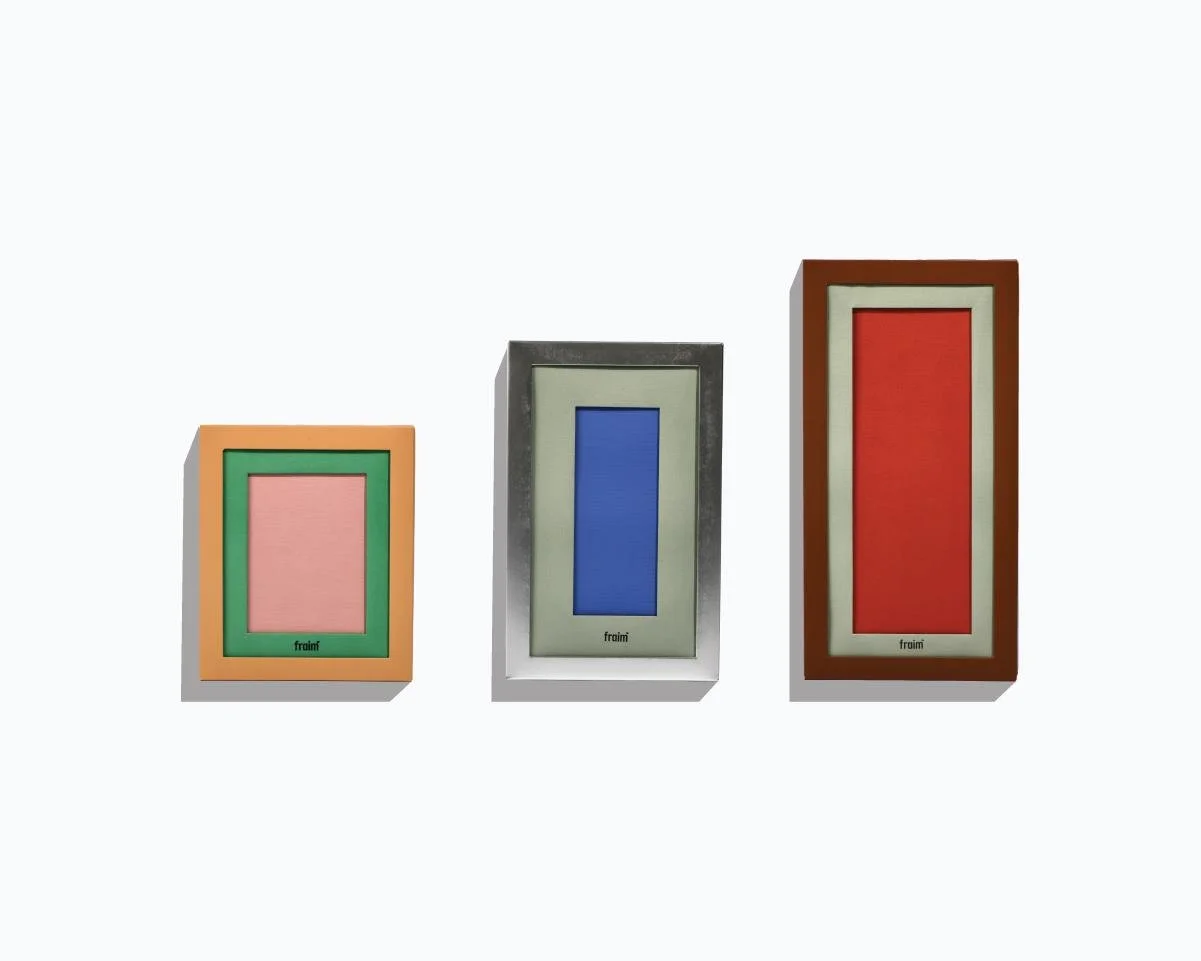 Three colorful picture frames with different colored mats, arranged from left to right, on a plain light background.
