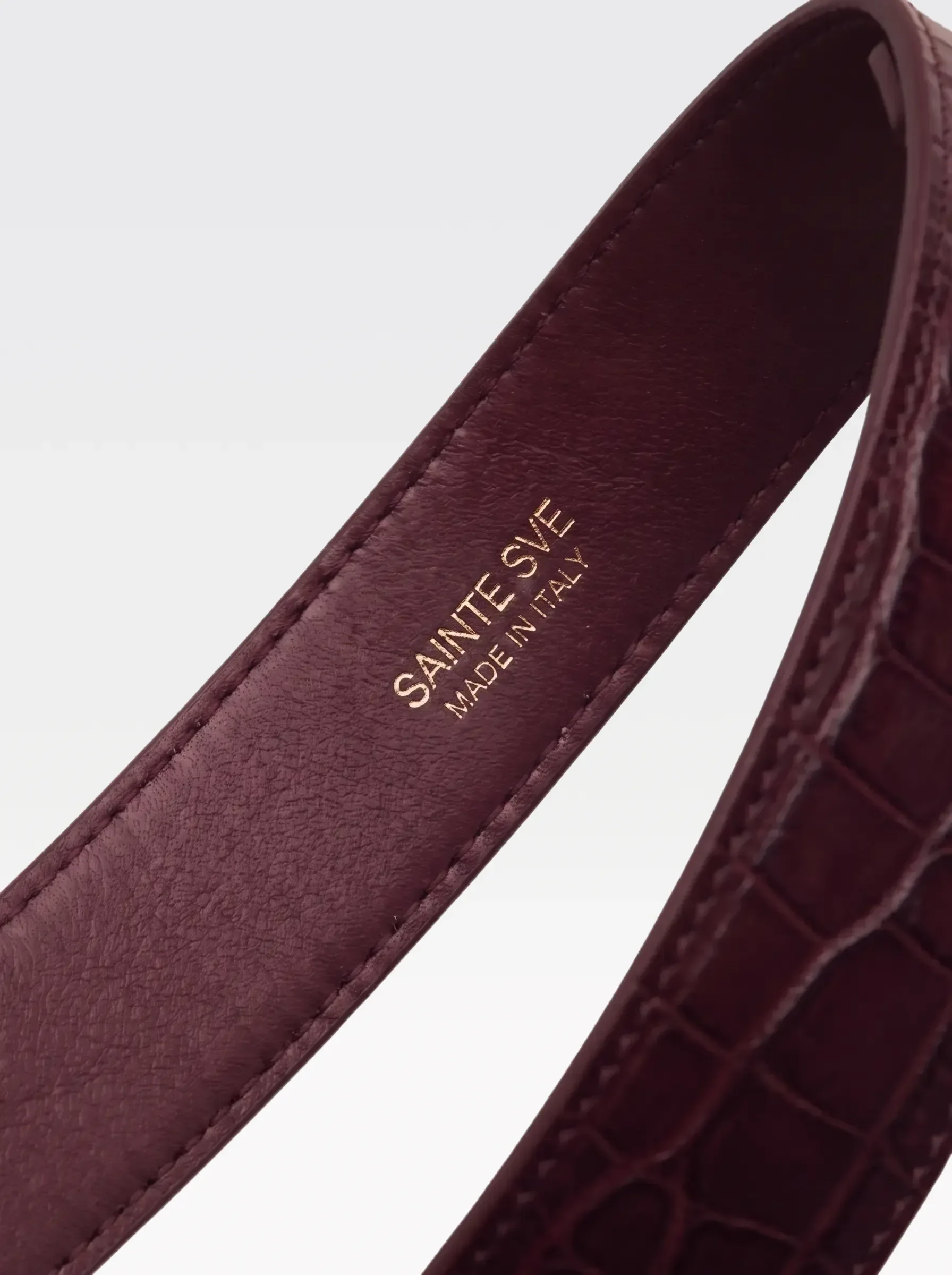 Close-up of the burgundy nappa lambskin lining of the Sainte Sve Garters Croc with the foil-stamped Sainte Sve Made in Italy logo
