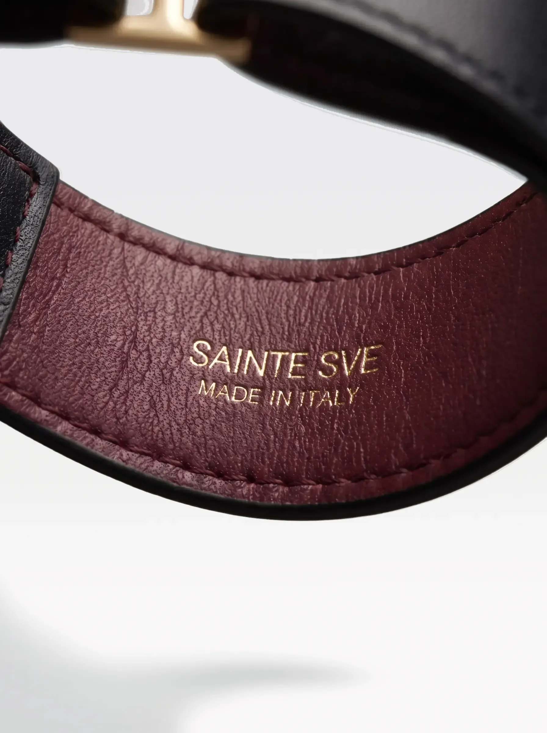 Close-up of the burgundy nappa lambskin lining of the Sainte Sve Choker Nappa with the foil-stamped Sainte Sve Made in Italy logo