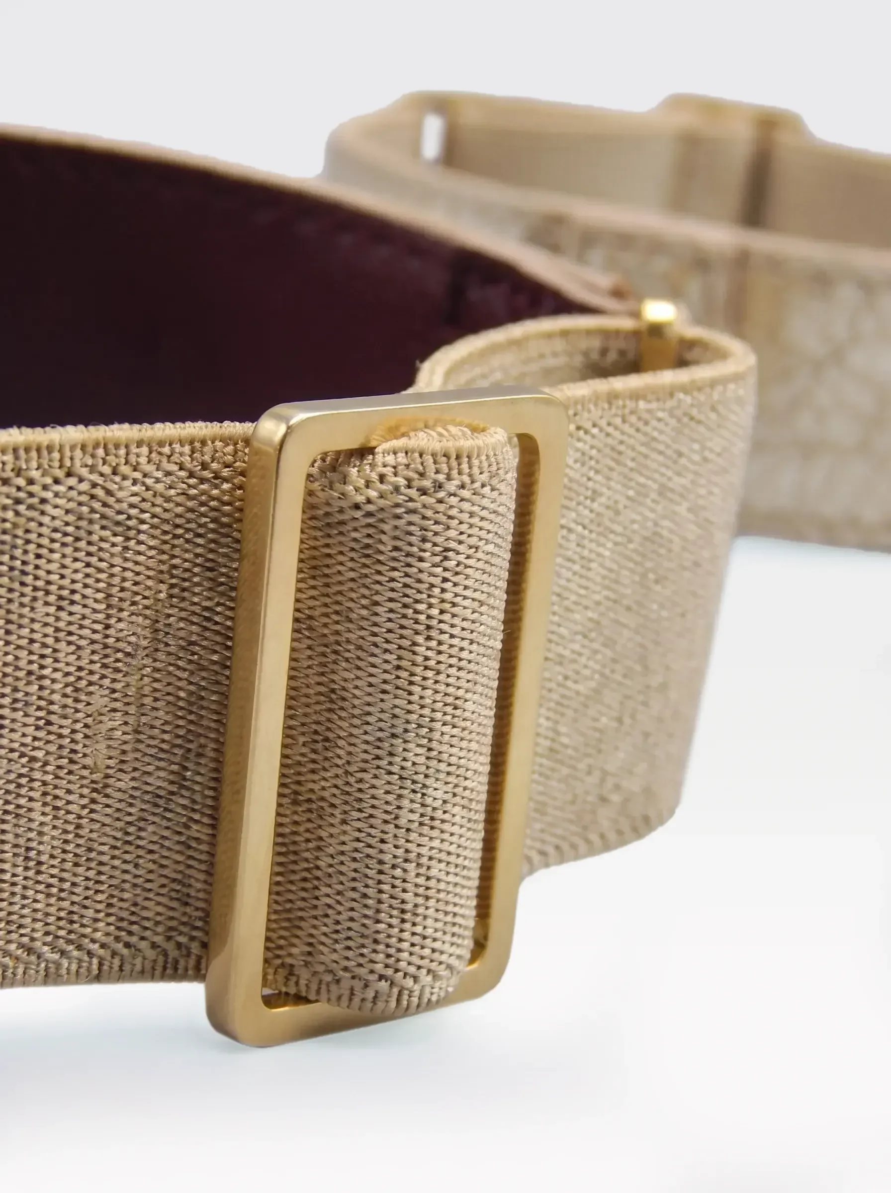 Close-up of the 24K gold-plated brass slider on the gold elastic band of a Sainte Sve Arm Bracelets Laminated