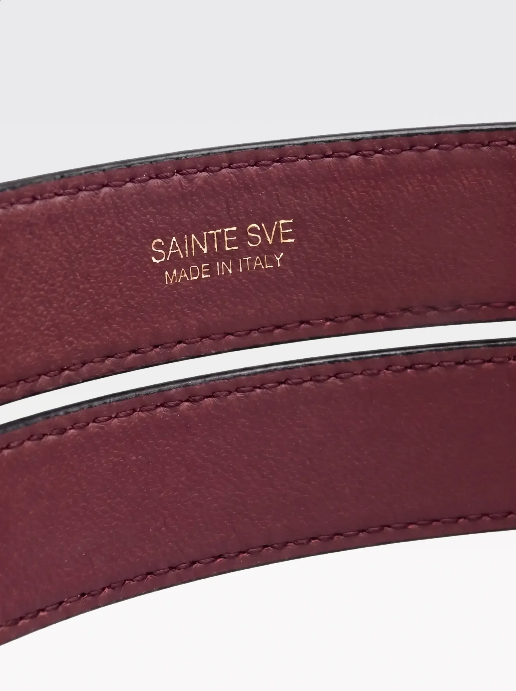 Close-up of the burgundy nappa lambskin lining of the Sainte Sve Belt Nappa with the foil-stamped Sainte Sve Made in Italy logo