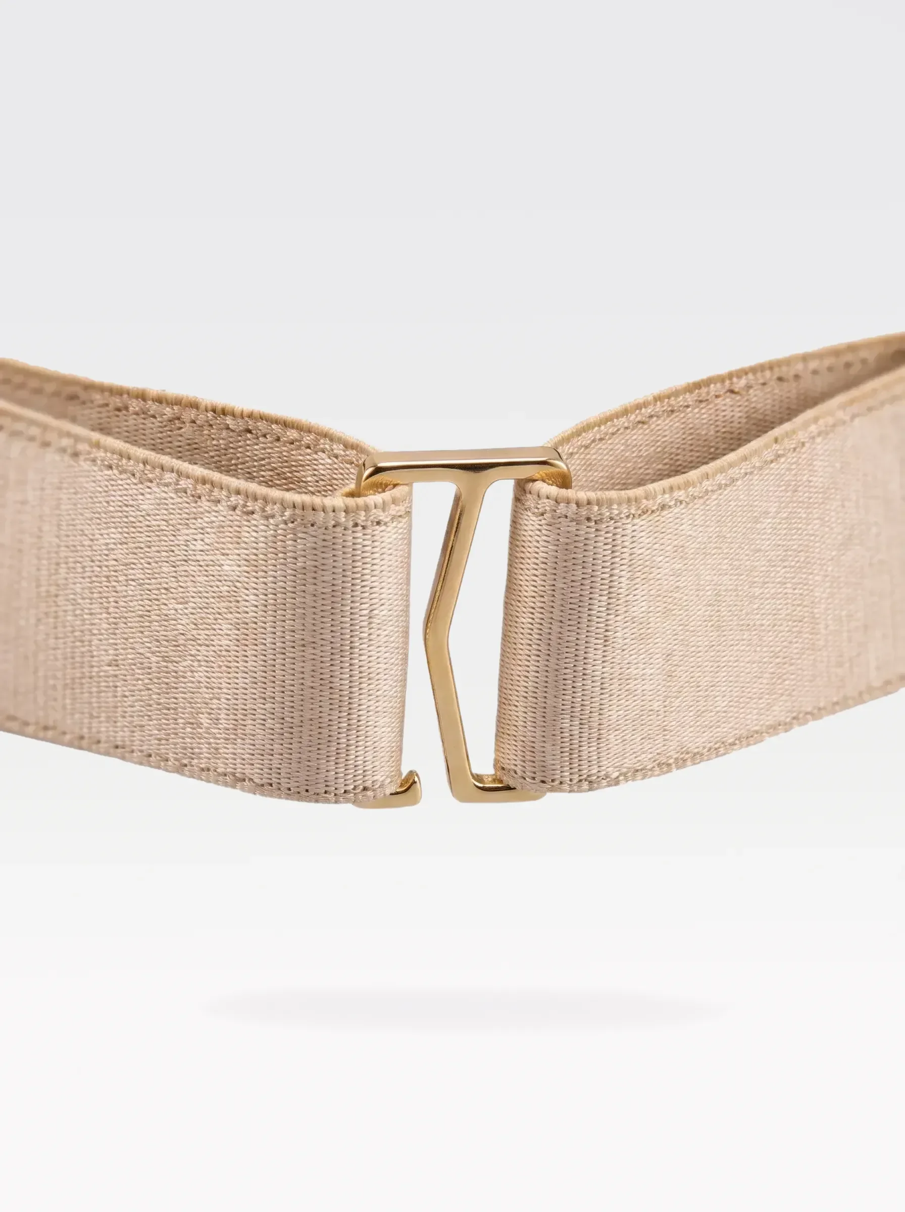 Close-up of the 24K gold-plated brass G hook closure on the gold elastic band of a Sainte Sve Belt Laminated