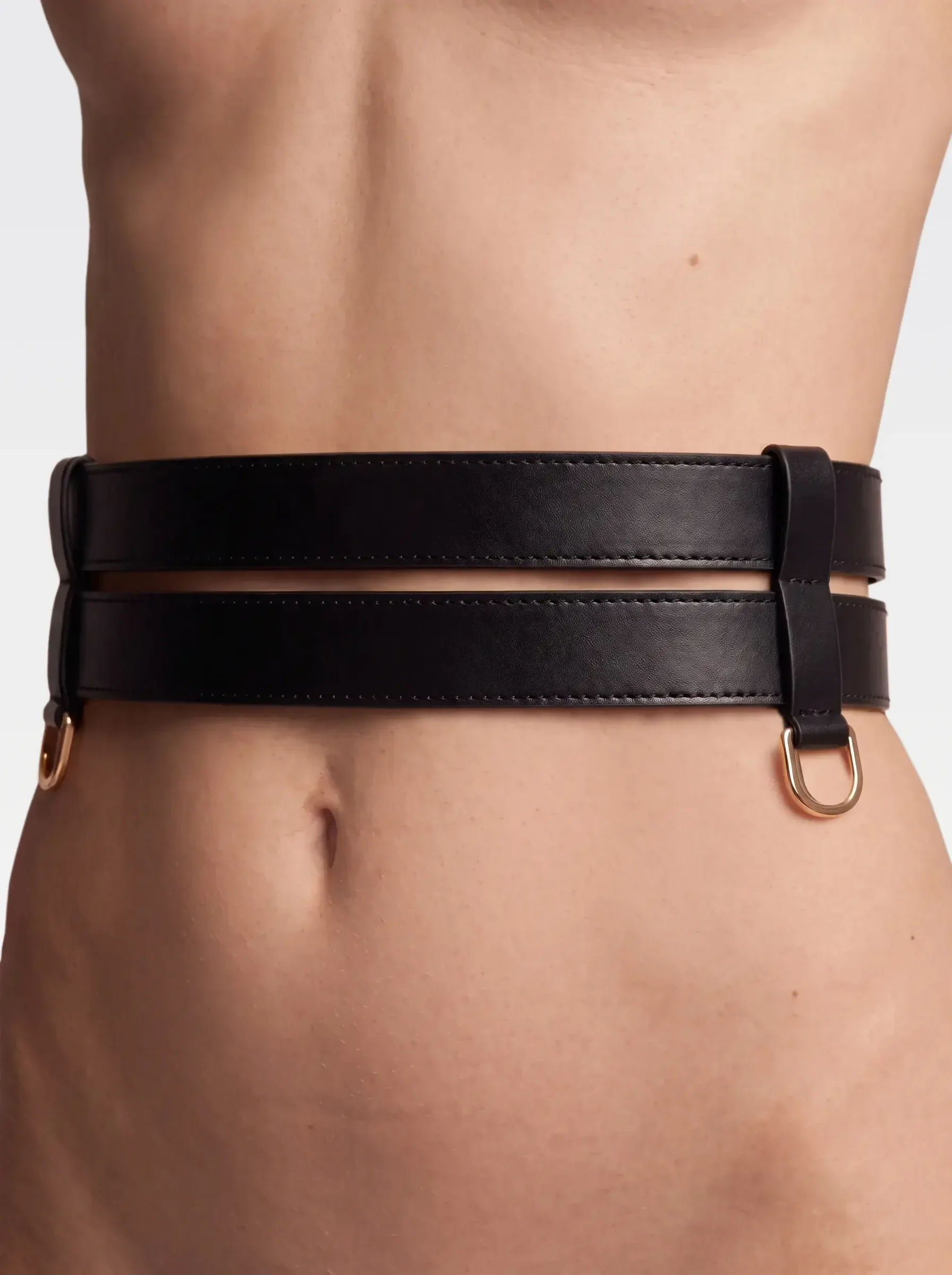 Sainte Sve Belt Nappa in black nappa lambskin with 24K gold-plated brass D ring, worn at the waist, editorial image