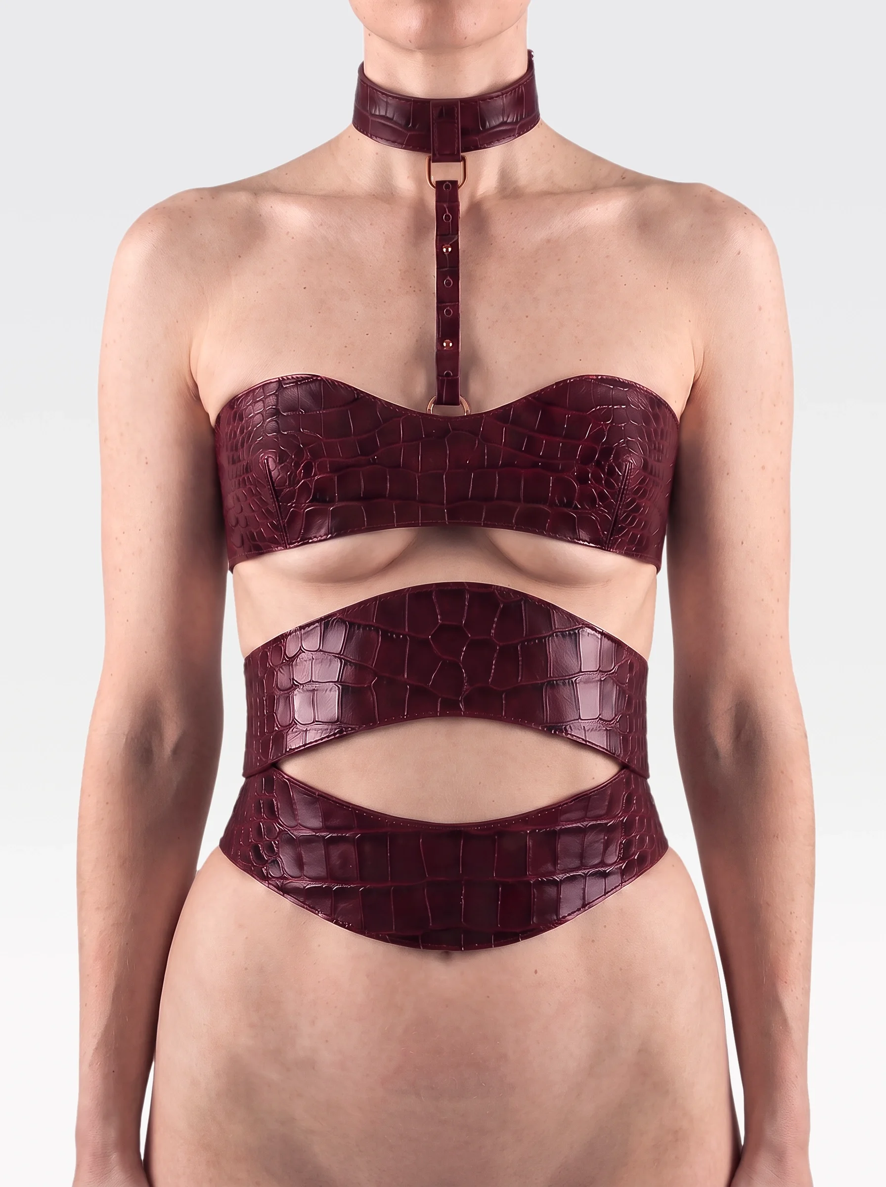 Sainte Sve V.N.V Croc in burgundy crocodile-embossed lambskin with burgundy elastic bands and zip, worn from neck to waist, front view, editorial image