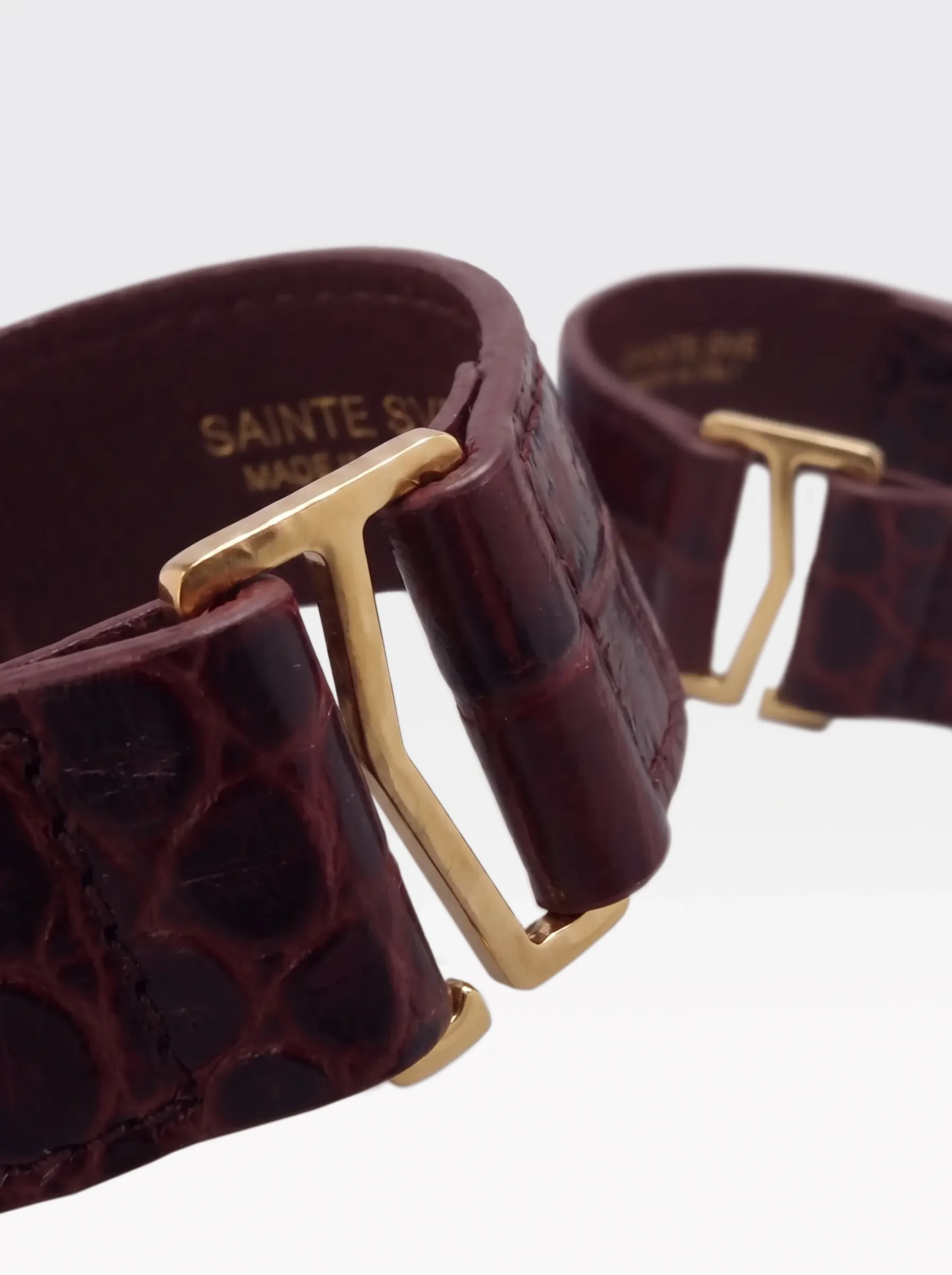 Close-up of the burgundy nappa lambskin lining of the Sainte Sve Wrist Bracelets Croc with the foil-stamped Sainte Sve Made in Italy logo