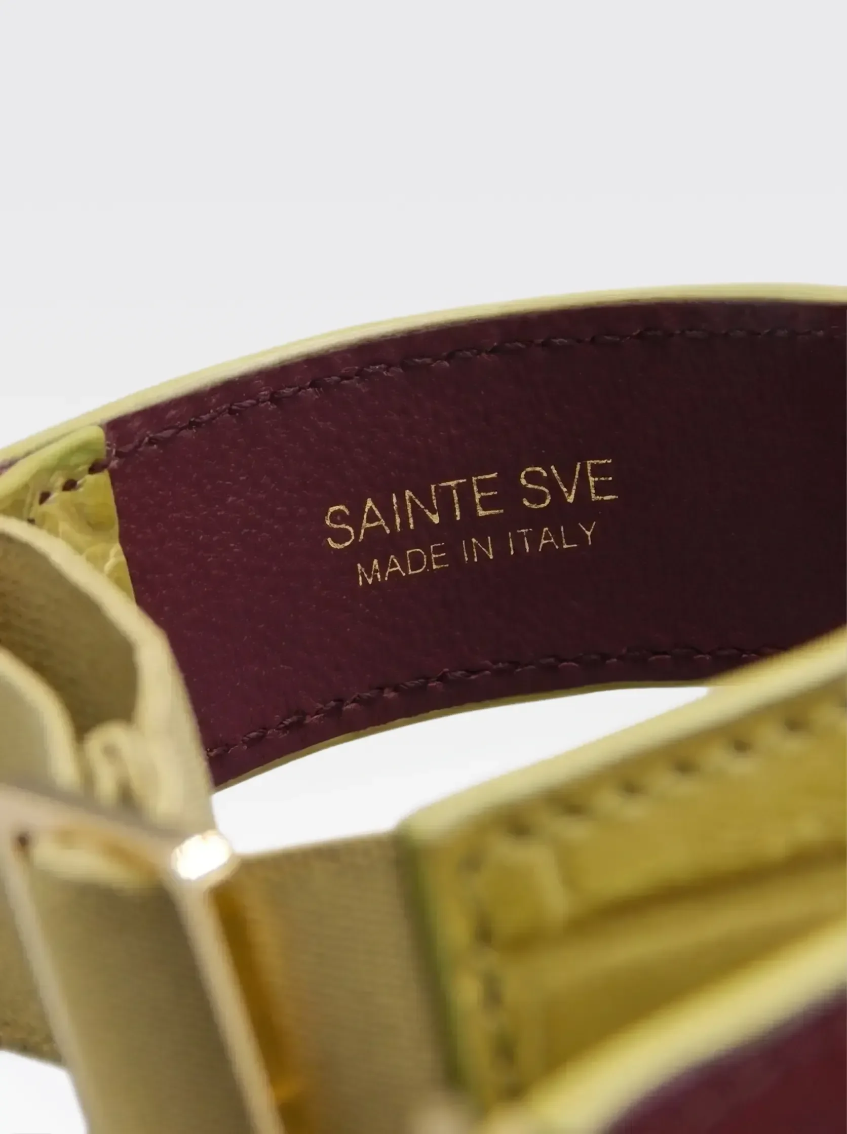Close-up of the burgundy nappa lambskin lining of the Sainte Sve Arm Bracelets Croc with the foil-stamped Sainte Sve Made in Italy logo