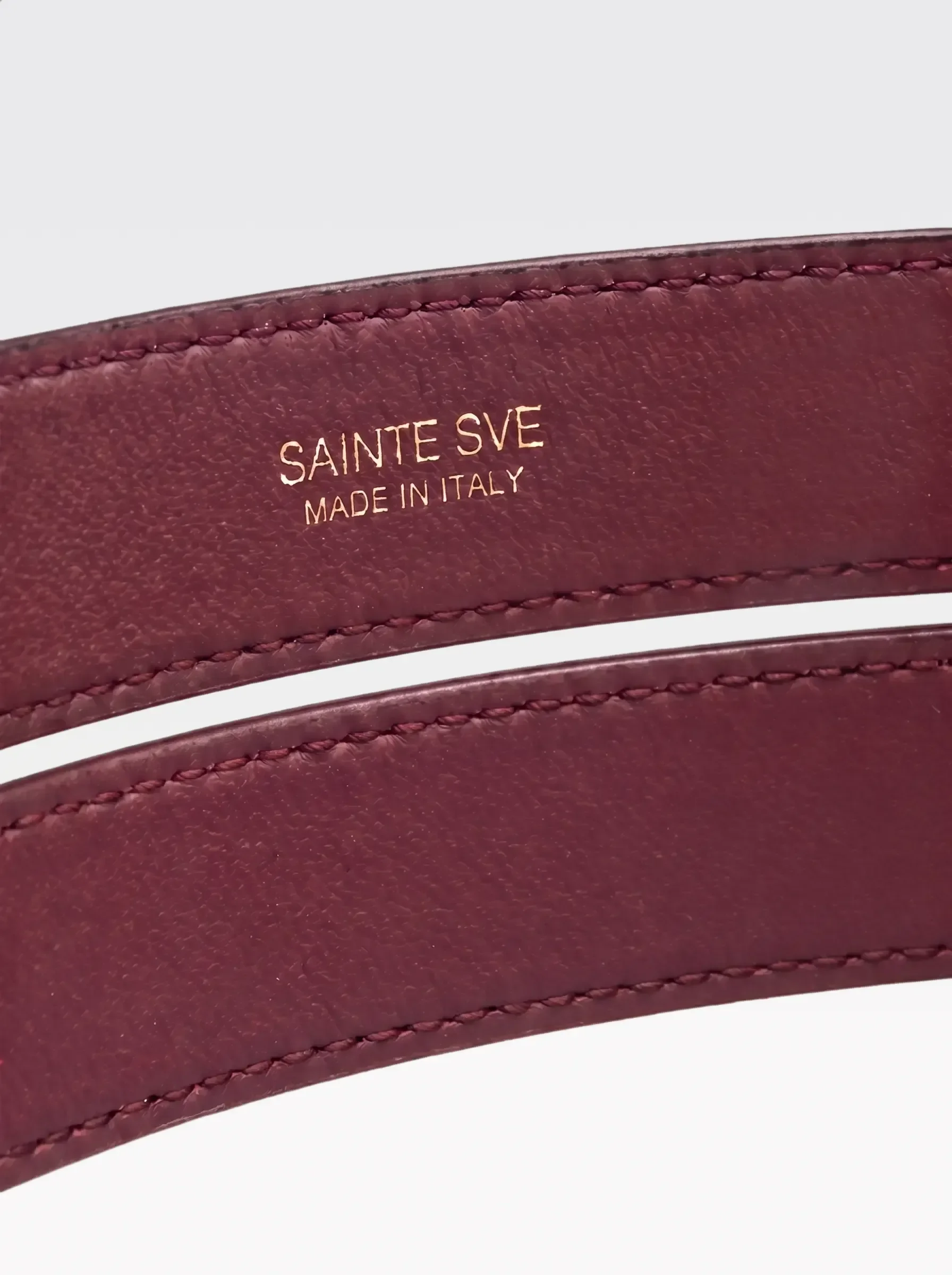 Close-up of the burgundy nappa lambskin lining of the Sainte Sve Belt Croc with the foil-stamped Sainte Sve Made in Italy logo
