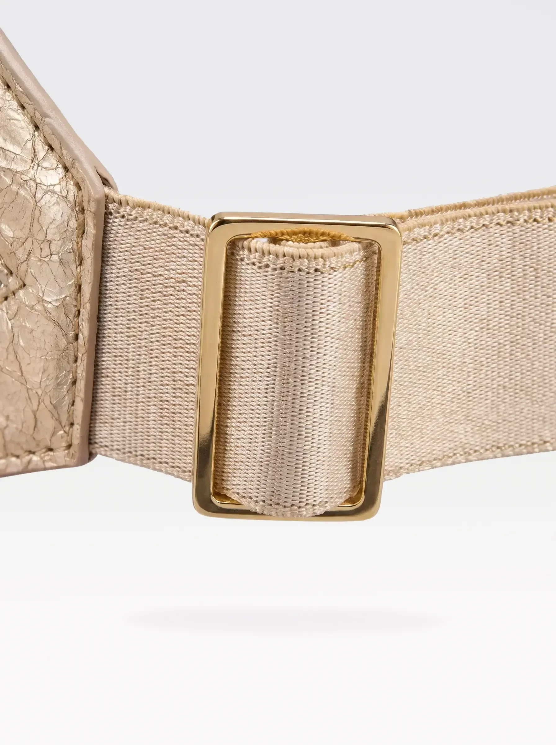 Close-up of the 24K gold-plated brass slider on the gold elastic band of a Sainte Sve Belt Laminated