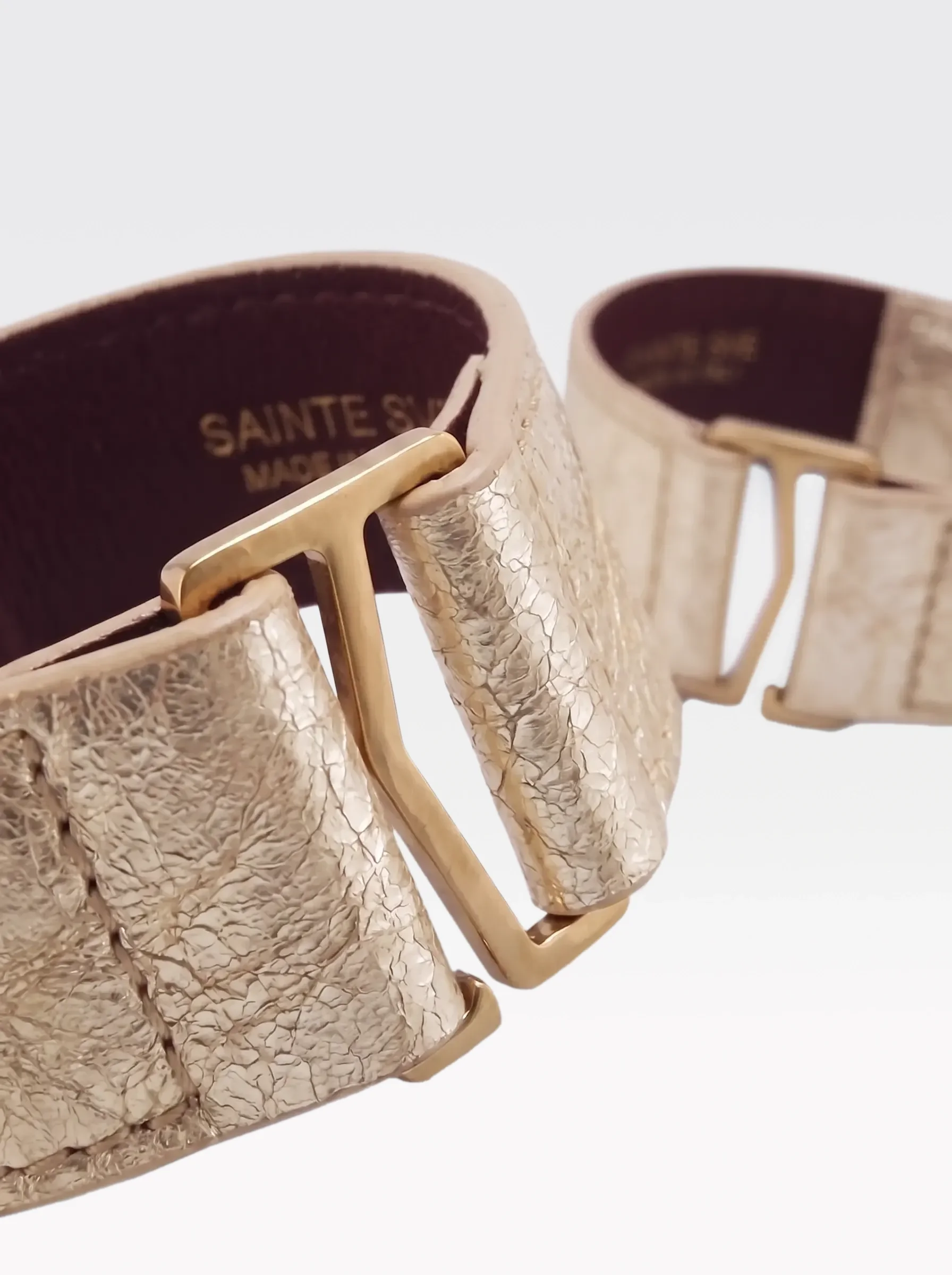 Close-up of the burgundy nappa lambskin lining of the Sainte Sve Wrist Bracelets Laminated with the foil-stamped Sainte Sve Made in Italy logo