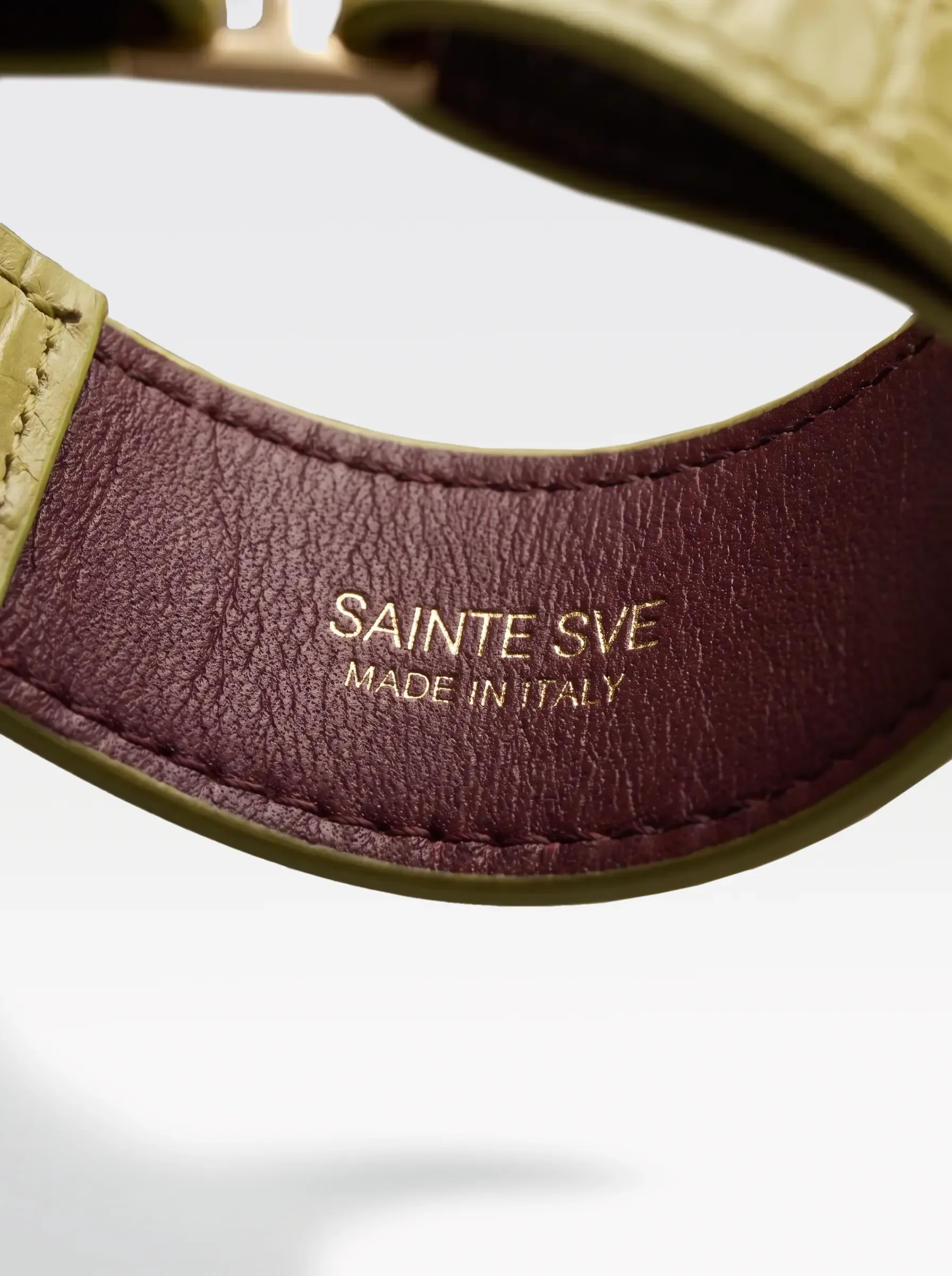 Close-up of the burgundy nappa lambskin lining of the Sainte Sve Choker Croc with the foil-stamped Sainte Sve Made in Italy logo